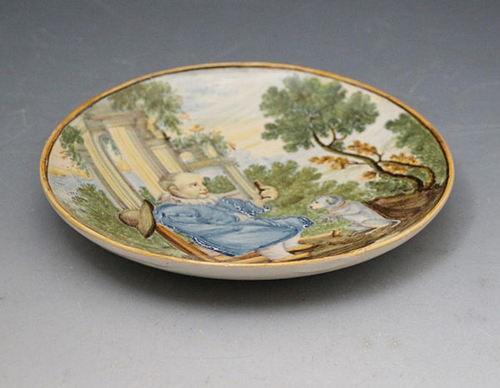 Dated: 1650 to 1700 Italy

A charming Italian hand decorated dish showing a seated male figure offering his dog a morsel. 
The quality of the painting is exceptional with a sublime soft color palette.

Diameter: 6.00inch

Medium: pottery