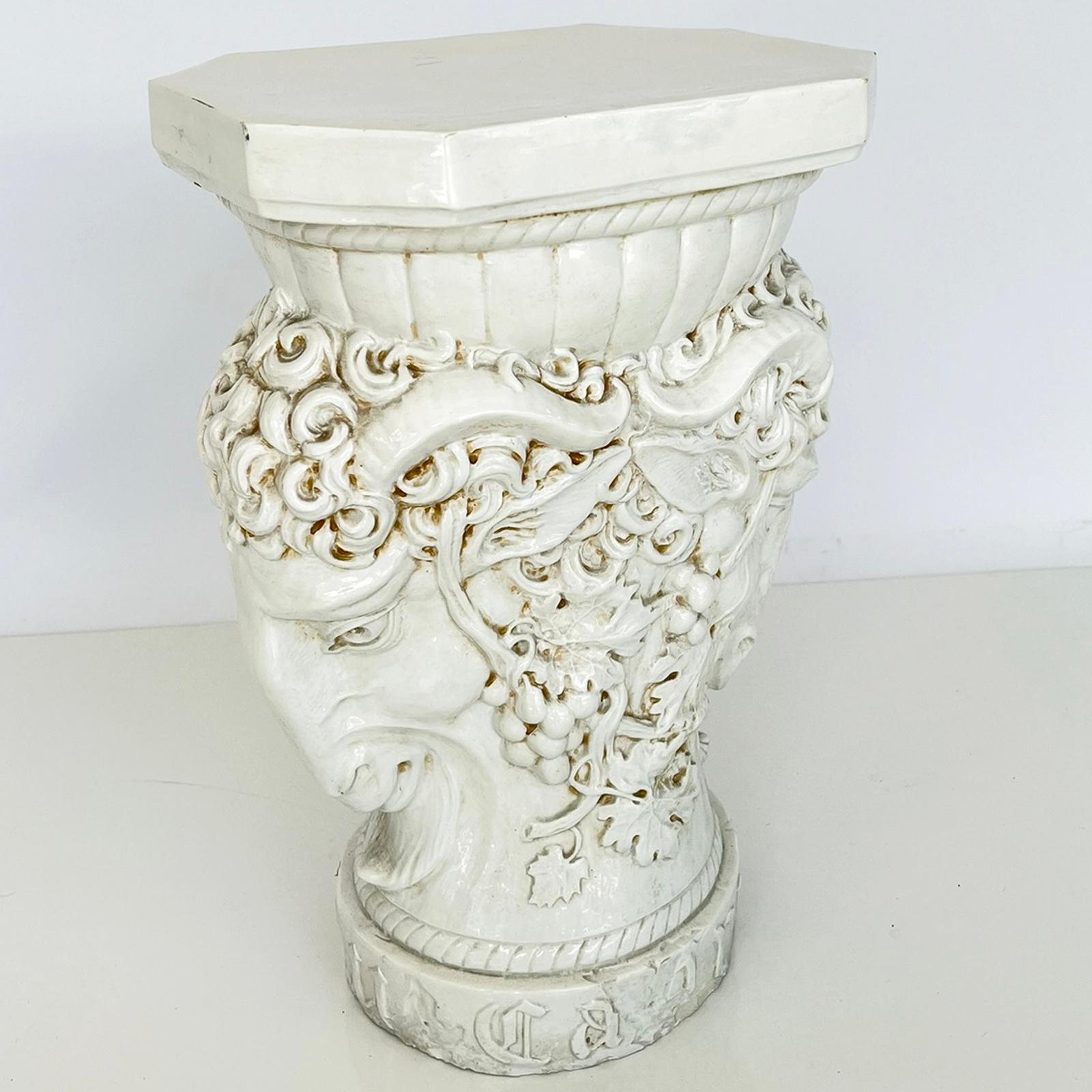 Pottery garden stool, cast from an antique fragment, with creamware-colored glaze, having a rectangular top with canted corners, it's base a well-articulated, double-headed ram, decorated with scrolling grapevines, on a round foot with rope border,