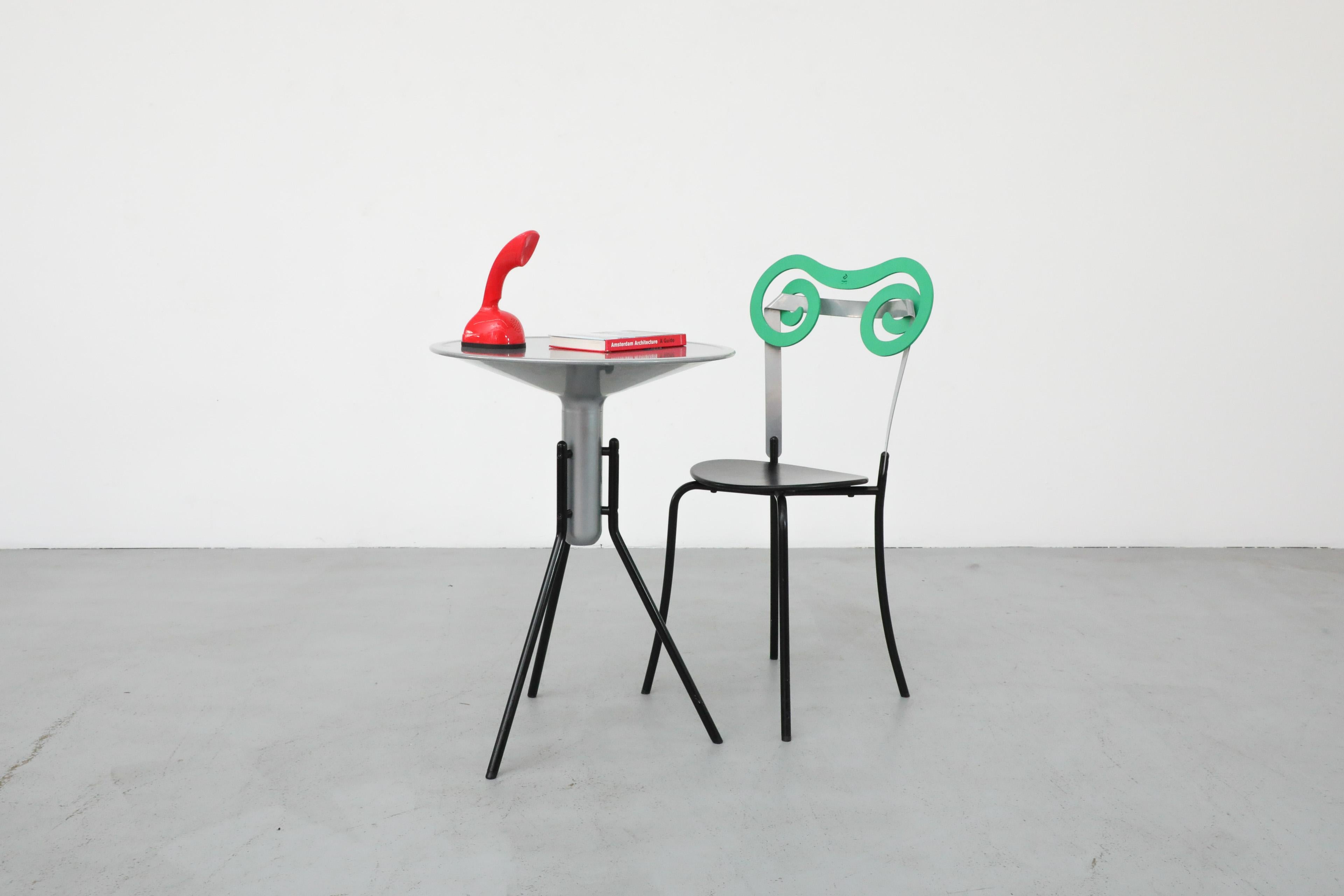 MOD Ensemble table et chaise bistro italienne Progetti. Un ensemble de table unique, de style moderne, parfait pour un coin ou un espace extérieur confortable et bien couvert. La table a un plateau rond en aluminium sur des pieds tripodes noirs qui