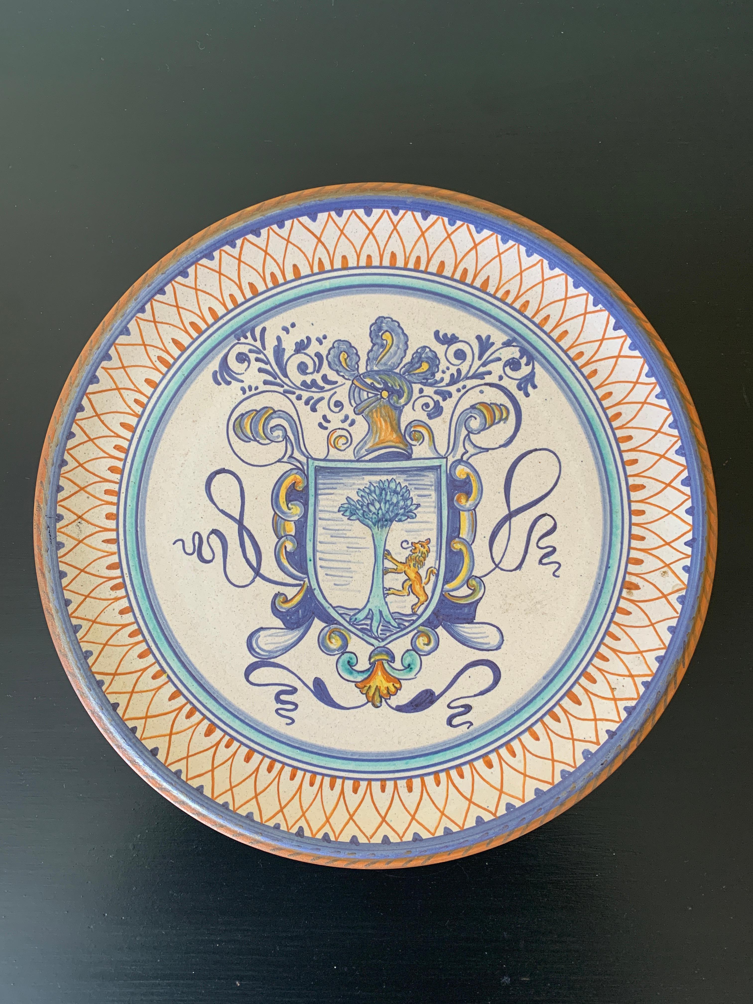 A beautiful hand painted blue, cream, and yellow faience pottery wall plate featuring a coat of arms crest.

By Fidia Deruta

Italy, Late-20th Century

Measures: 11
