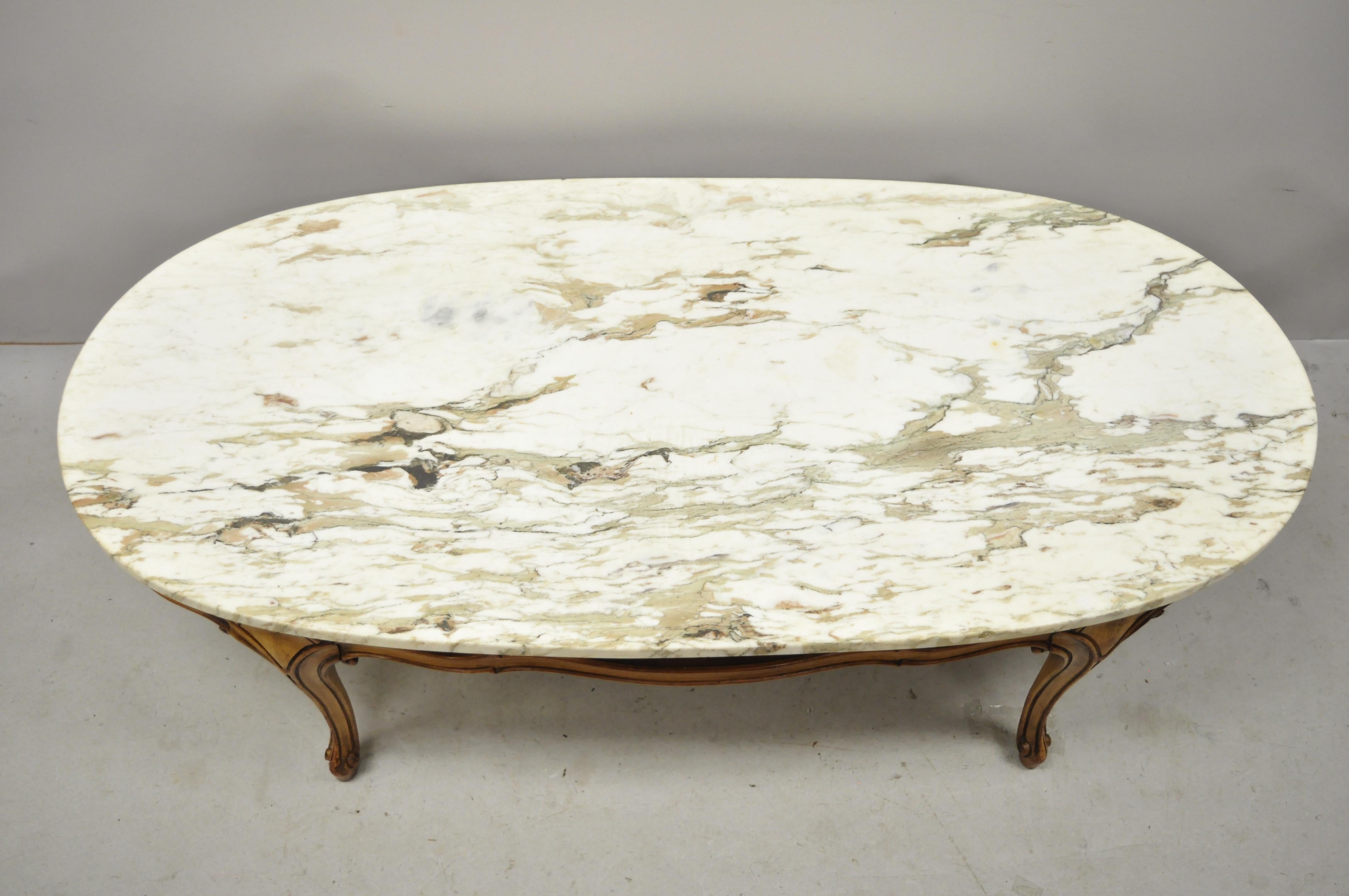 Vintage Italian Provincial French Hollywood Regency ribbon carved oval marble-top coffee table. Item features an oval marble top, solid wood frame, beautiful wood grain, cabriole legs, great style and form, circa mid-20th century.
Measurements: