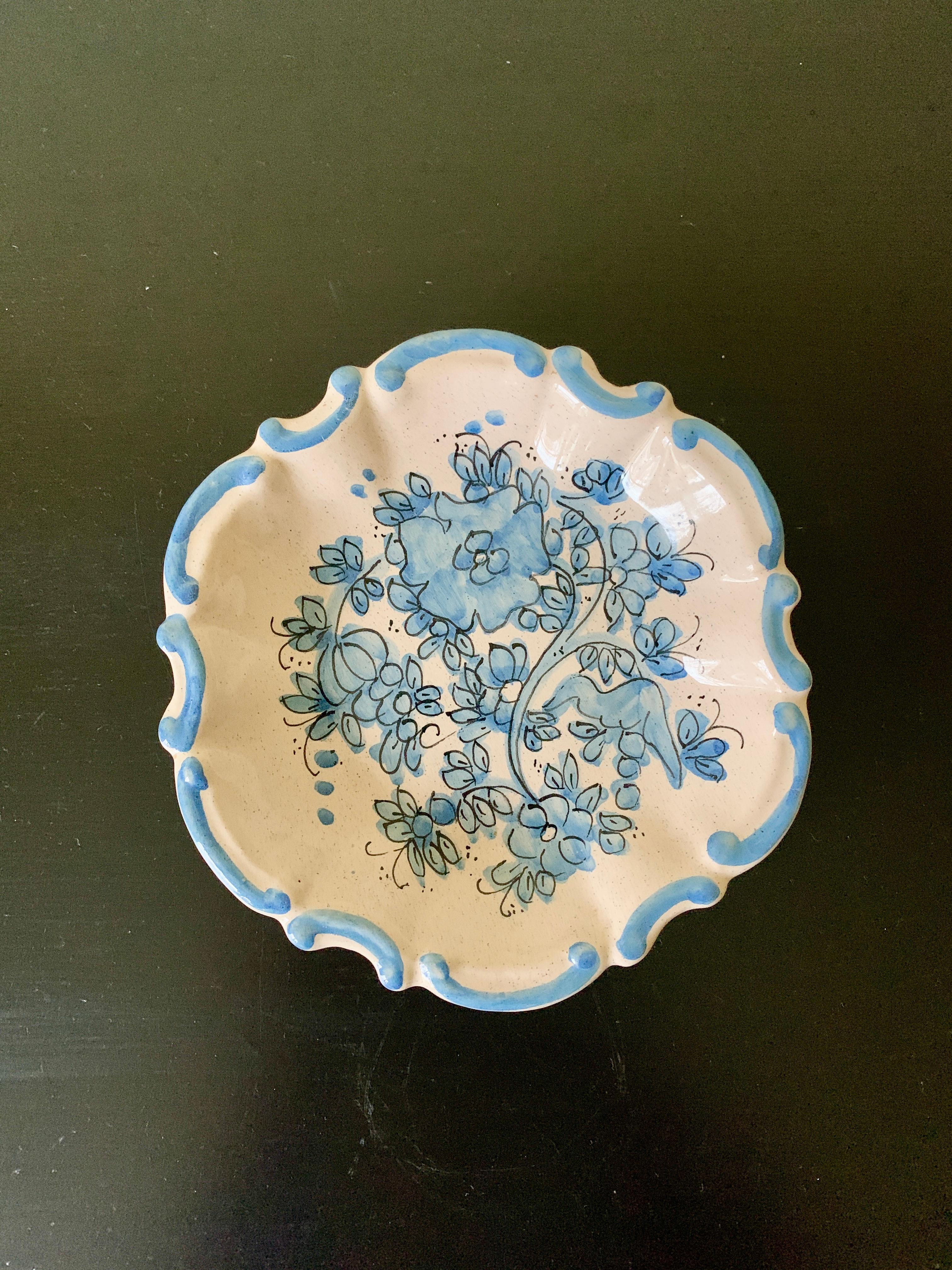 A beautiful French Provincial style hand painted blue and cream faience pottery wall plate featuring floral designs.

By Marcucci for Deruta

Italy, Late-20th Century

Measures: 5.25