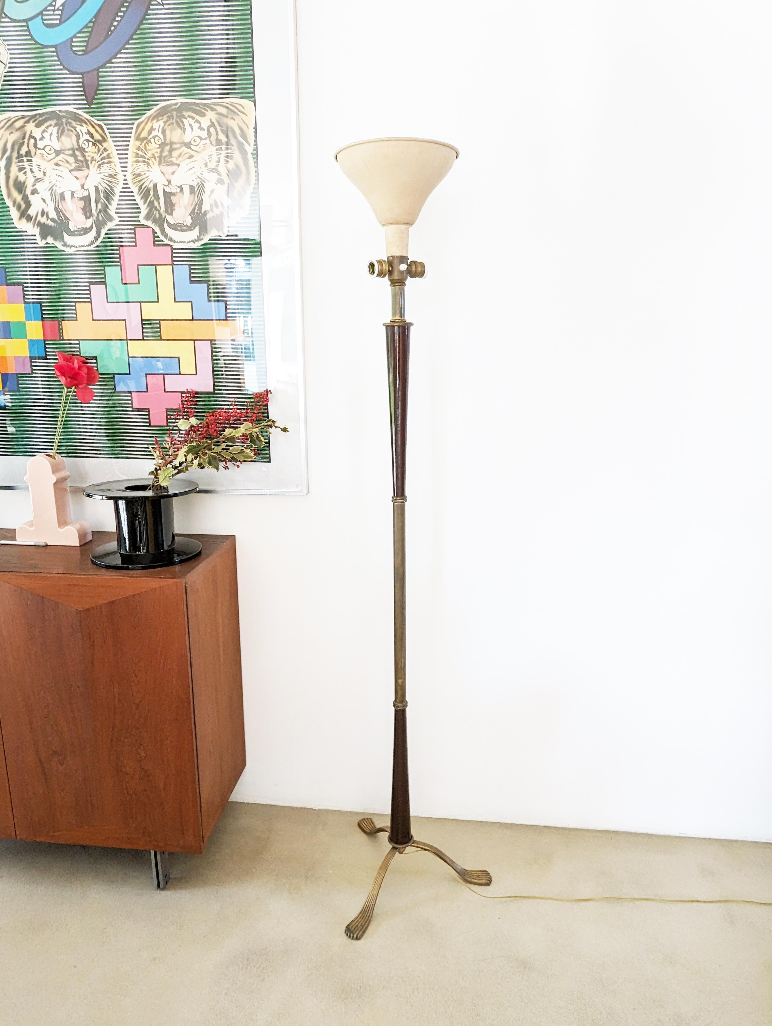 This elegant floor lamp was produced in Italy in the late 1940s. It is made from a brass structure with laquered wood elements. 

Its design remains rather classic, but the high quality of construction recalls contemporary examples of the production