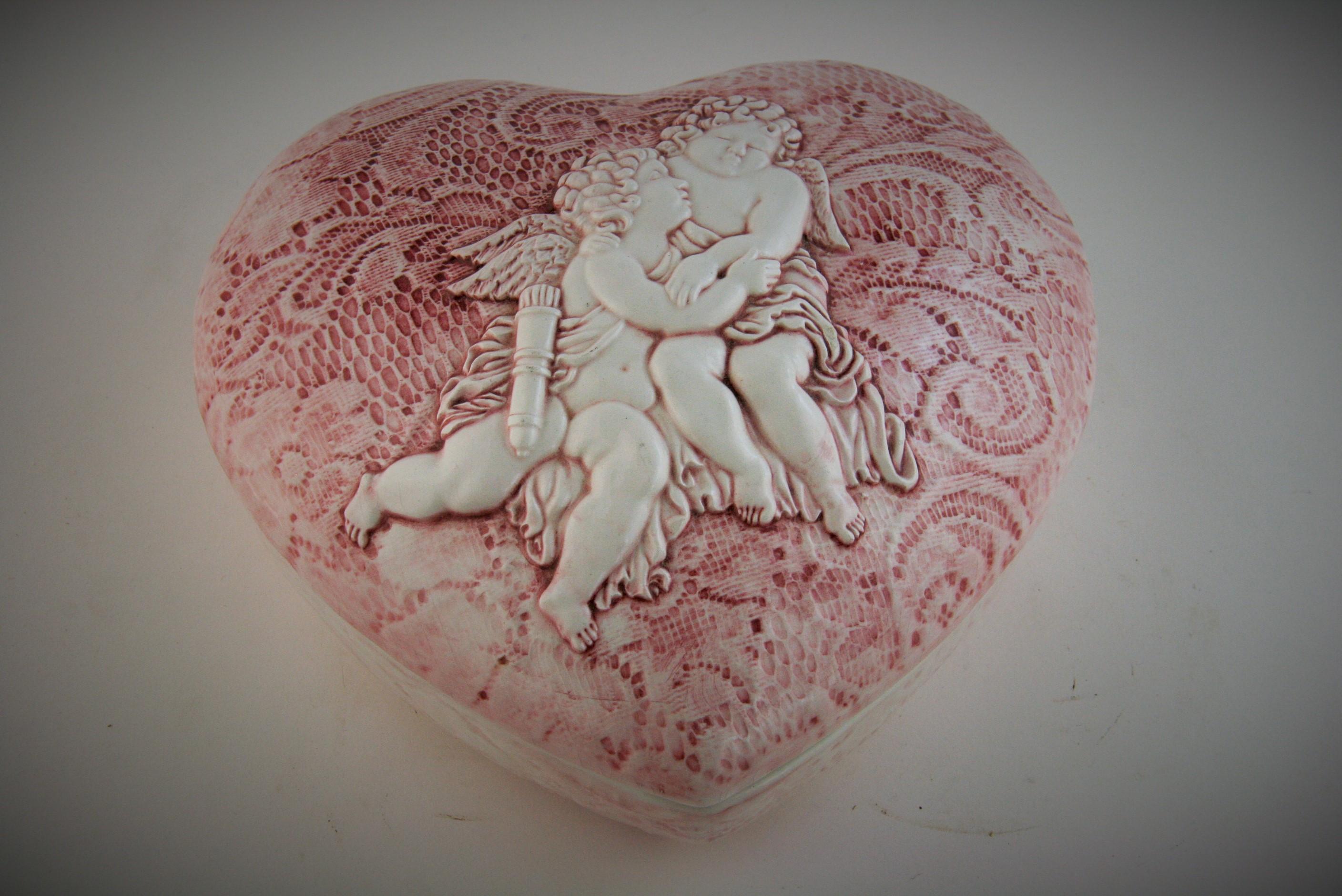 8-239 Italian heart shaped ceramic box with embracing putti top.
Rose colored embroidery detailing on top and bottom sections
Marked made in Italy on bottom.