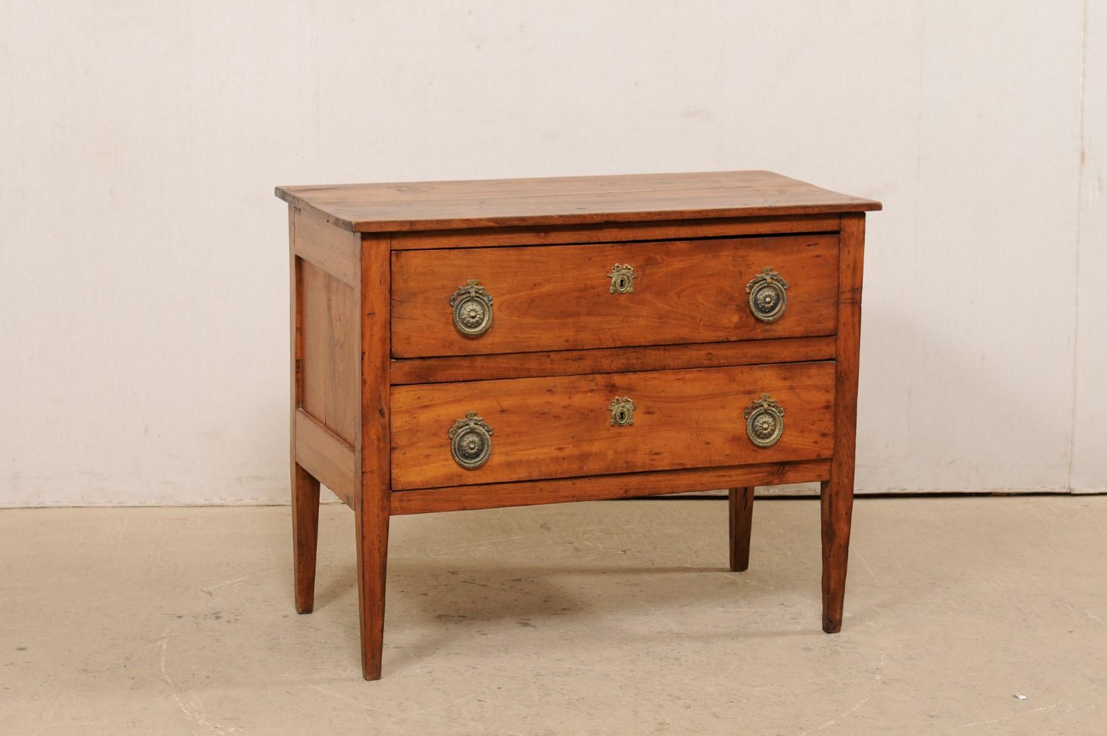 An Italian wood raised chest of two drawers from the turn of the 18th and 19th century. This antique cassettiera (chest of drawers) from Italy features a rectangular-shaped top, over a case which houses two full-sized drawers, designed in clean,