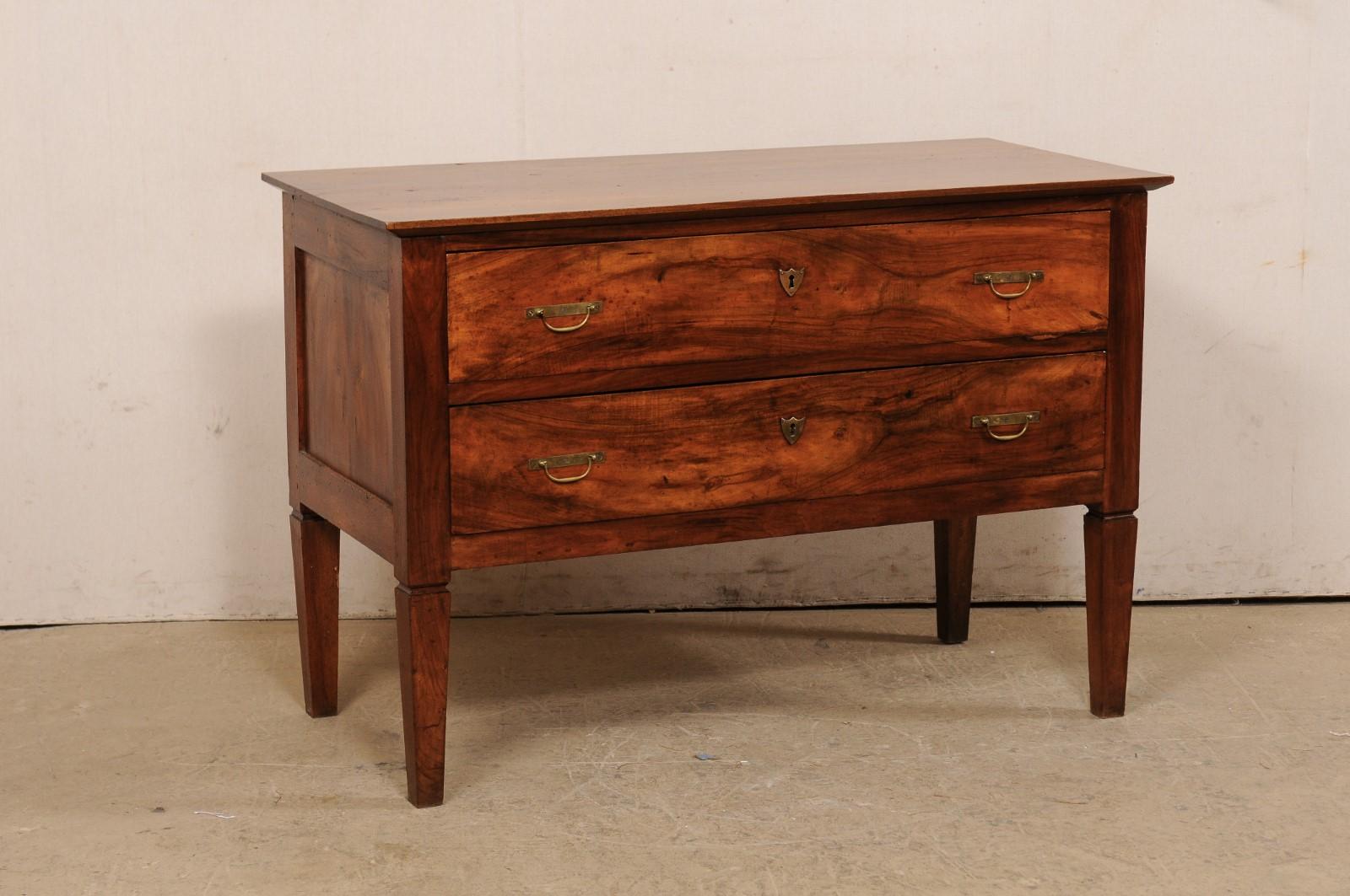 An Italian walnut raised chest of two drawers from the mid 19th century. This antique cassettiera (chest of drawers) from Italy features a rectangular-shaped top, which slightly overhands the case below which houses two full-sized drawers, each