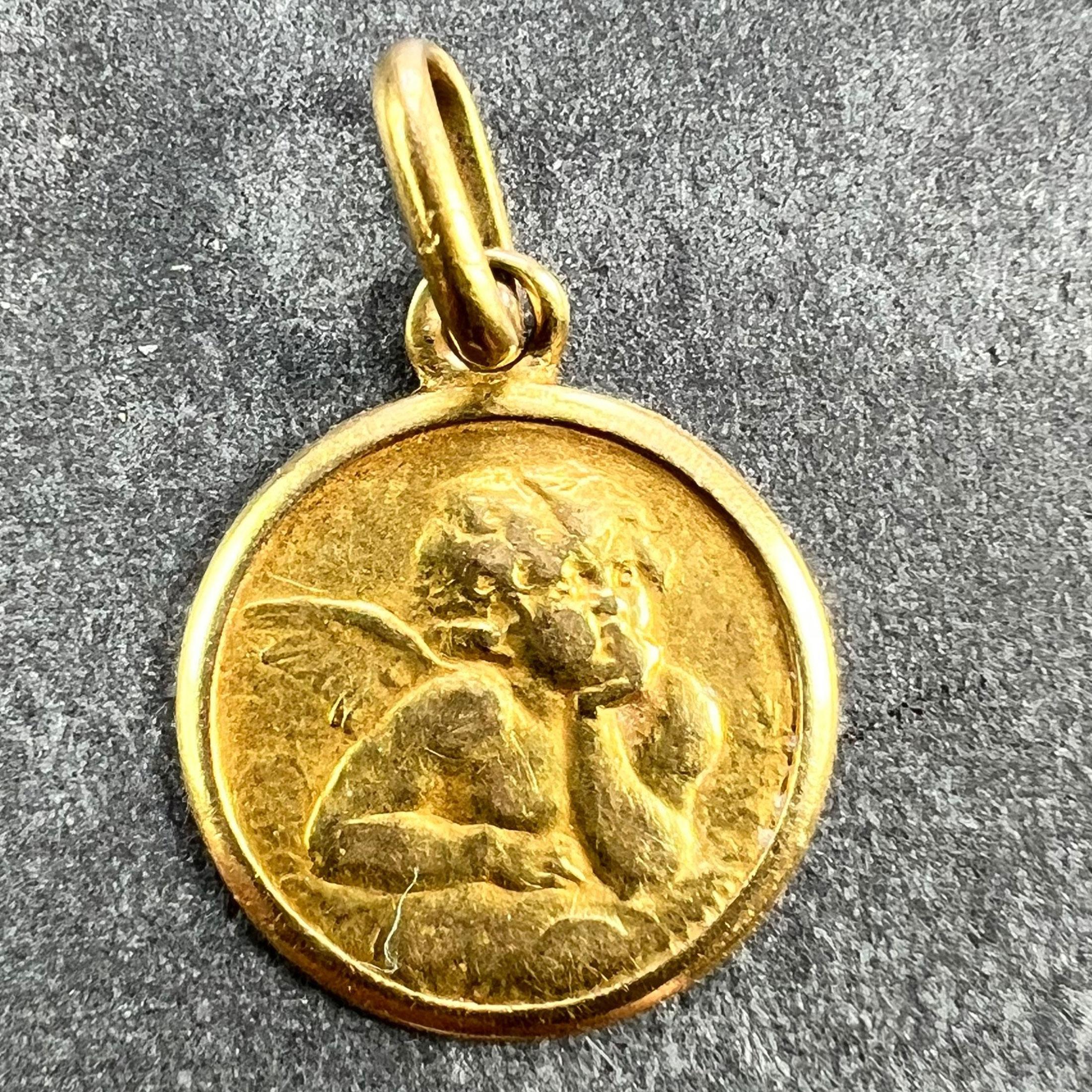 An Italian 18 karat (18K) yellow gold charm pendant designed as a medal depicting Raphael’s cherub within a raised frame. Stamped 750 for 18 karat gold and Italian manufacture with maker's mark 251MI for Bertoni SRL of Milan.

Dimensions: 1.3 x 1.1