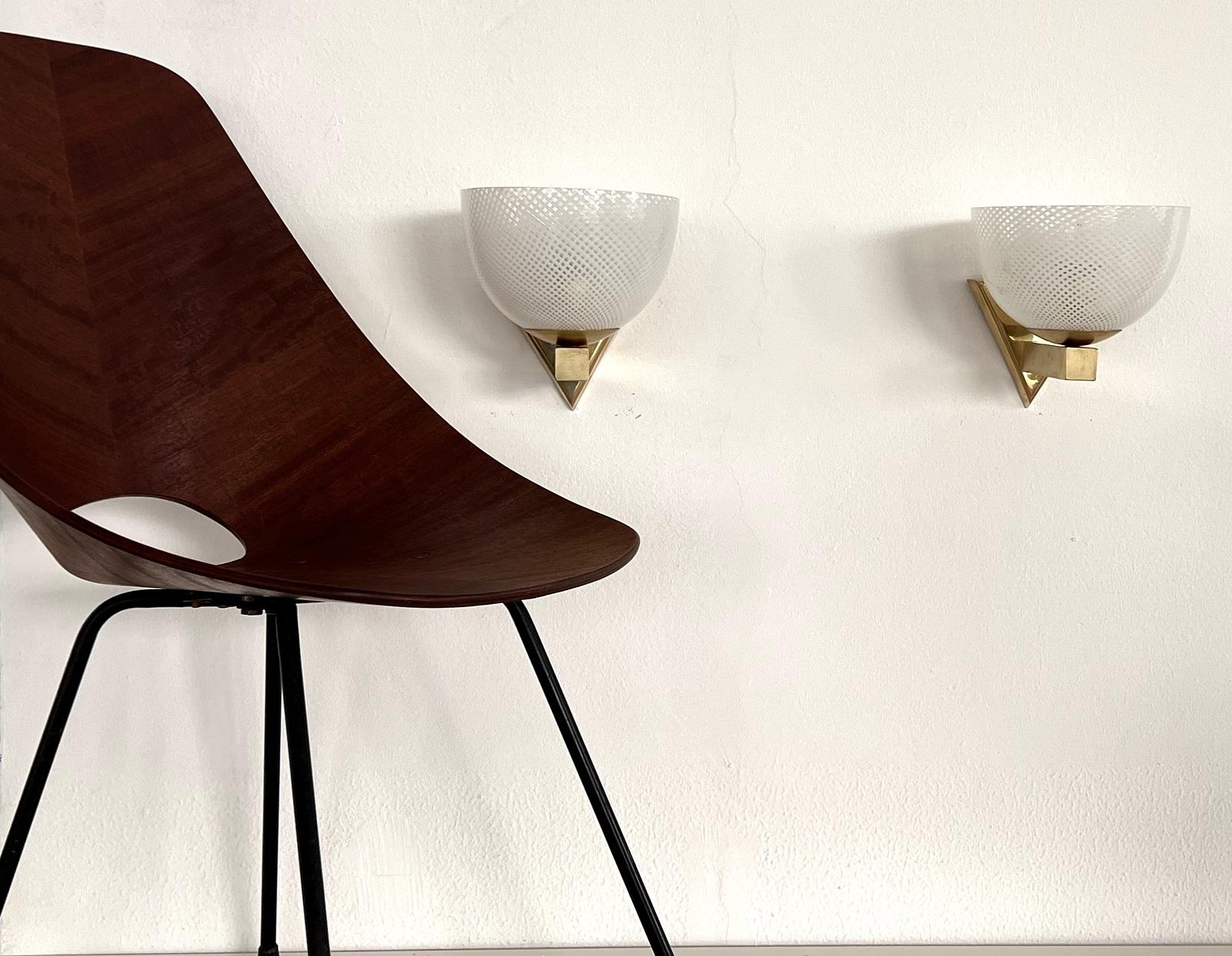 Beautiful set of two gorgeous, very rare, Murano Reticello Glass wall lights with strong brass base. Made in the Mid-century in Murano, Venice, Italy, in the style of Venini glass Manufacturing. 
The Reticello glasses are well known for Venini