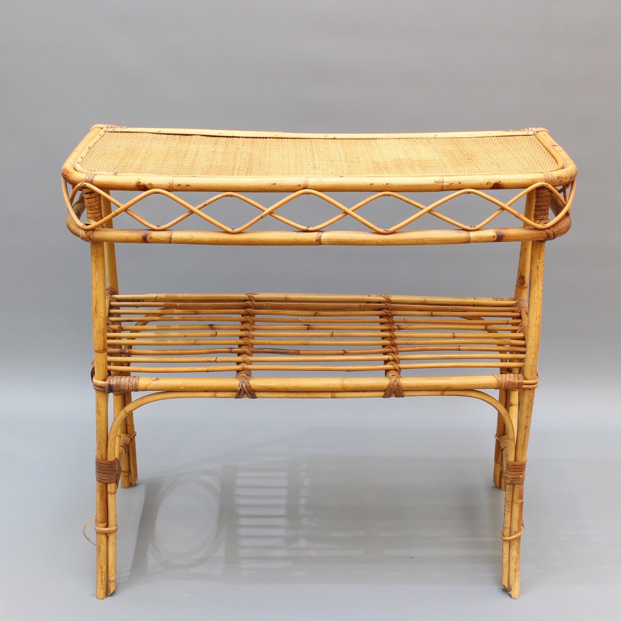 Italian rattan and bamboo console table (circa 1960s). A very stylish piece with a slew of character and charm. There are two horizontal surfaces for storage or display, the top made of tightly woven wicker. The smart-looking bamboo legs and frame