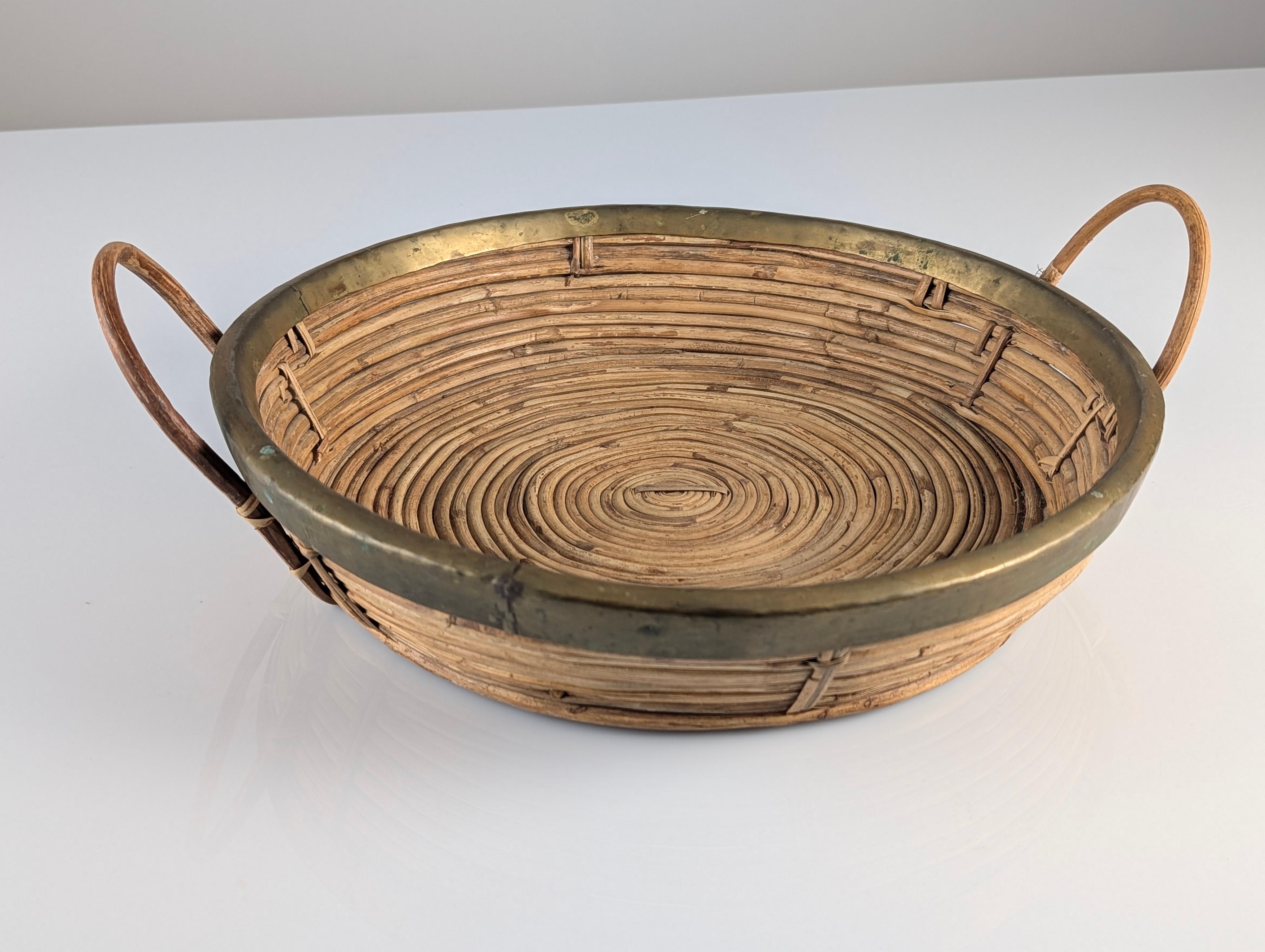 Elegant centerpiece basket that perfectly combines the warmth of hand-woven rattan with the sophisticated shine of polished brass handles and trim. Inspired by the iconic style of Gabriella Crespi, this Italian piece from the 1970s reflects the