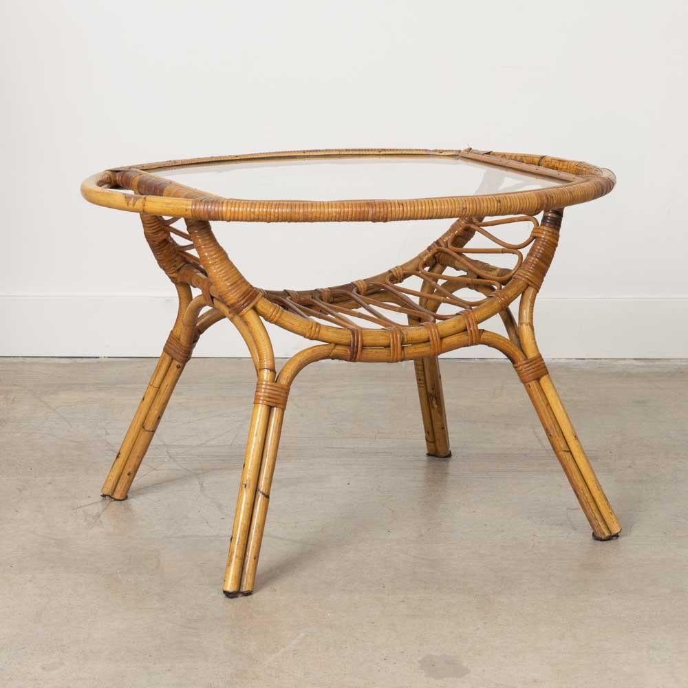 Great two-tier rattan and glass gueridon table from Italy, 1960s. Original rattan with original oval glass top, beautiful wavy rattan detail on lower shelf and wrapped rattan detailing on legs. Original rattan and glass show nice age and patina.