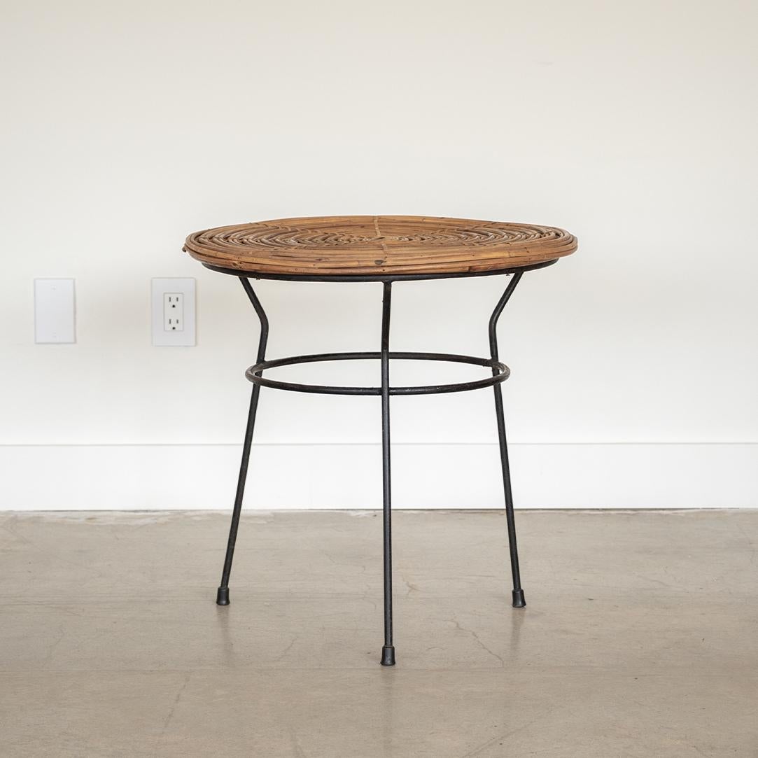 Beautiful rattan and iron circular table from Italy, 1950's. Original rattan table top with three angled black iron legs with original finish. Beautiful and functional design.