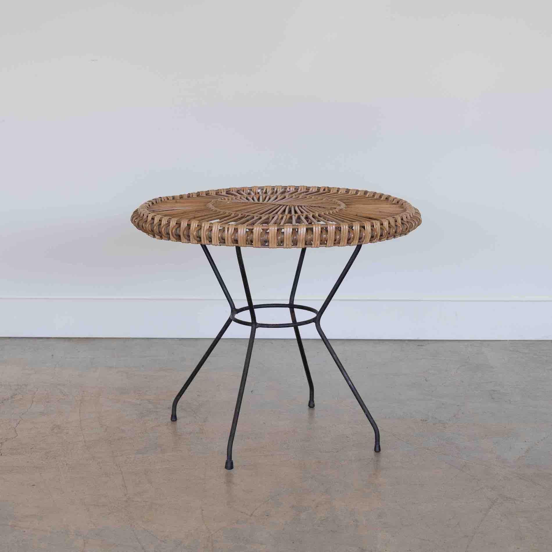 Stunning rattan side table from Italy, 1960's. Original rattan circular top with loop detail along edge. Iron frame with original black paint showing some signs of wear and age.
