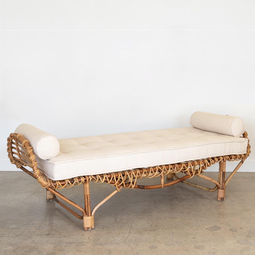 Vintage 1950's Italian rattan daybed by Lorenzo Forges Davanzati for Bonacina. Long wrapped rattan bed with curved sides. Newly added cushion and bolstered in light taupe ticking. Beautiful statement piece.