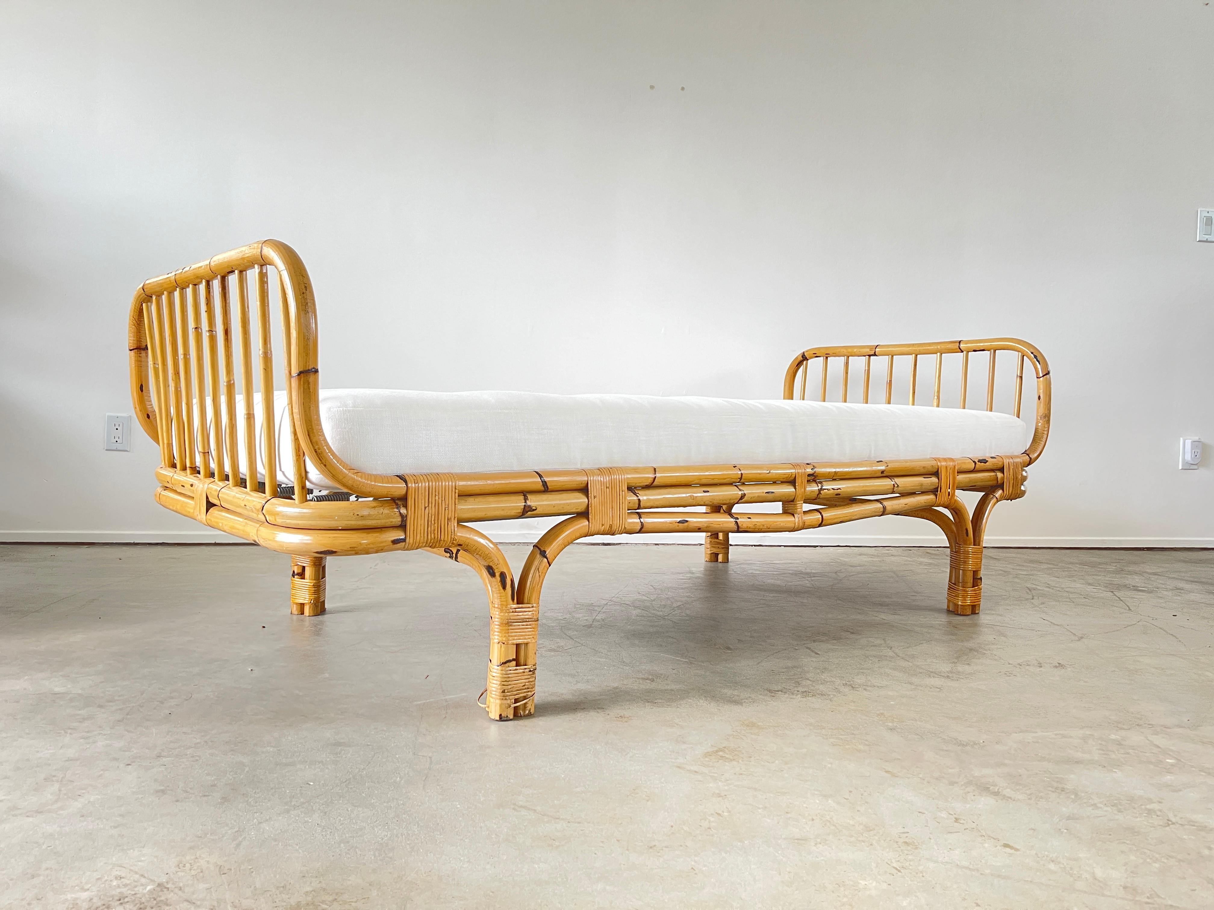 Italian bamboo daybed.
Reupholstered in crisp white linen. 
Sculptural bamboo headrest and footrest.

 