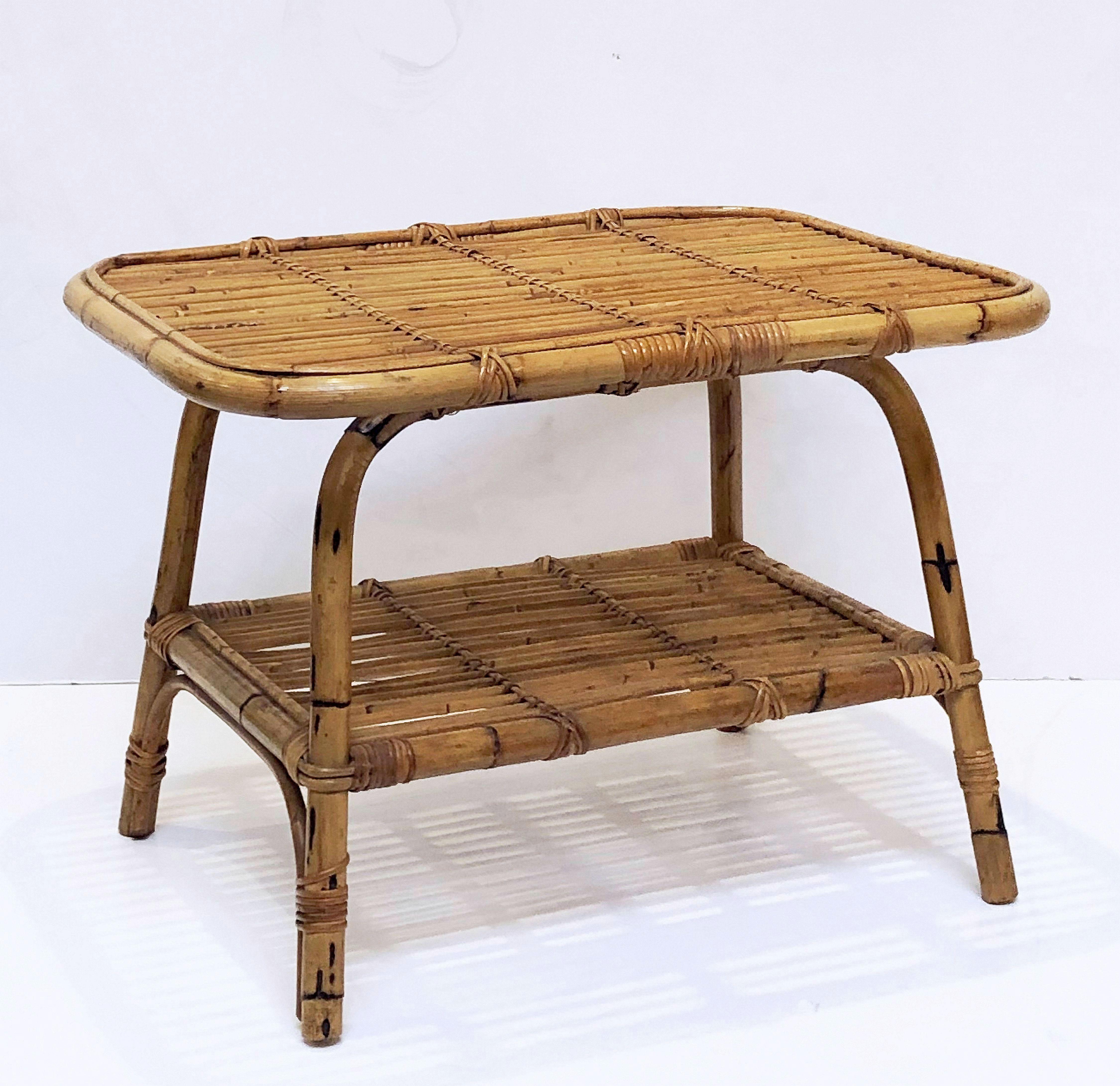 A fine Italian handcrafted midcentury rattan and bamboo side or end table.
Featuring a two-tiered body with decorative accents, the rectangular top tier with rounded corners over a bottom tier stretcher with four legs.

Great for a patio or tiki