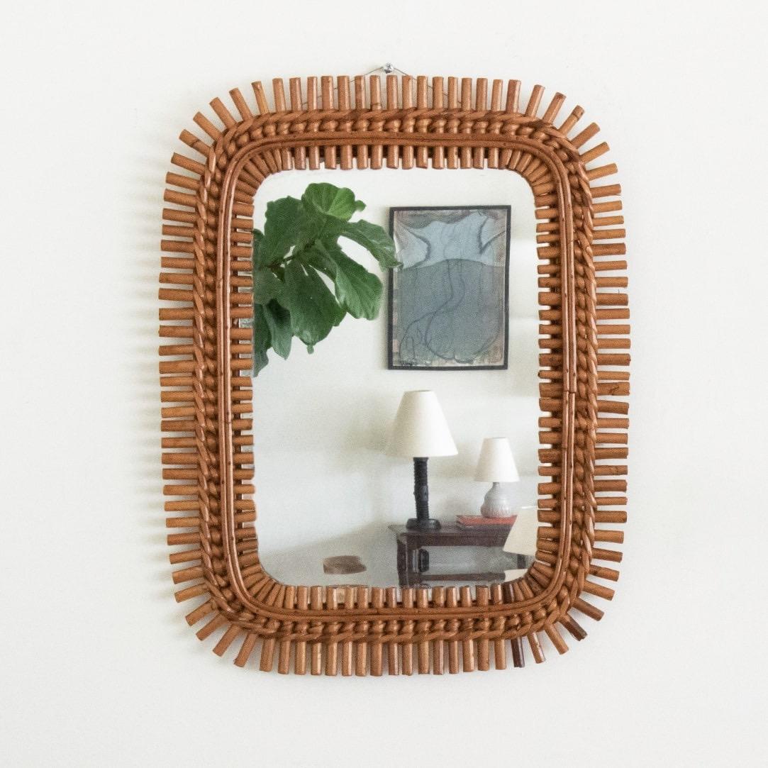 Italian rattan mirror in a rectangular shape with rattan encompassing the mirror. Nice vintage condition with original coloring and mirror. Beautiful mirror, perfect for a powder room.