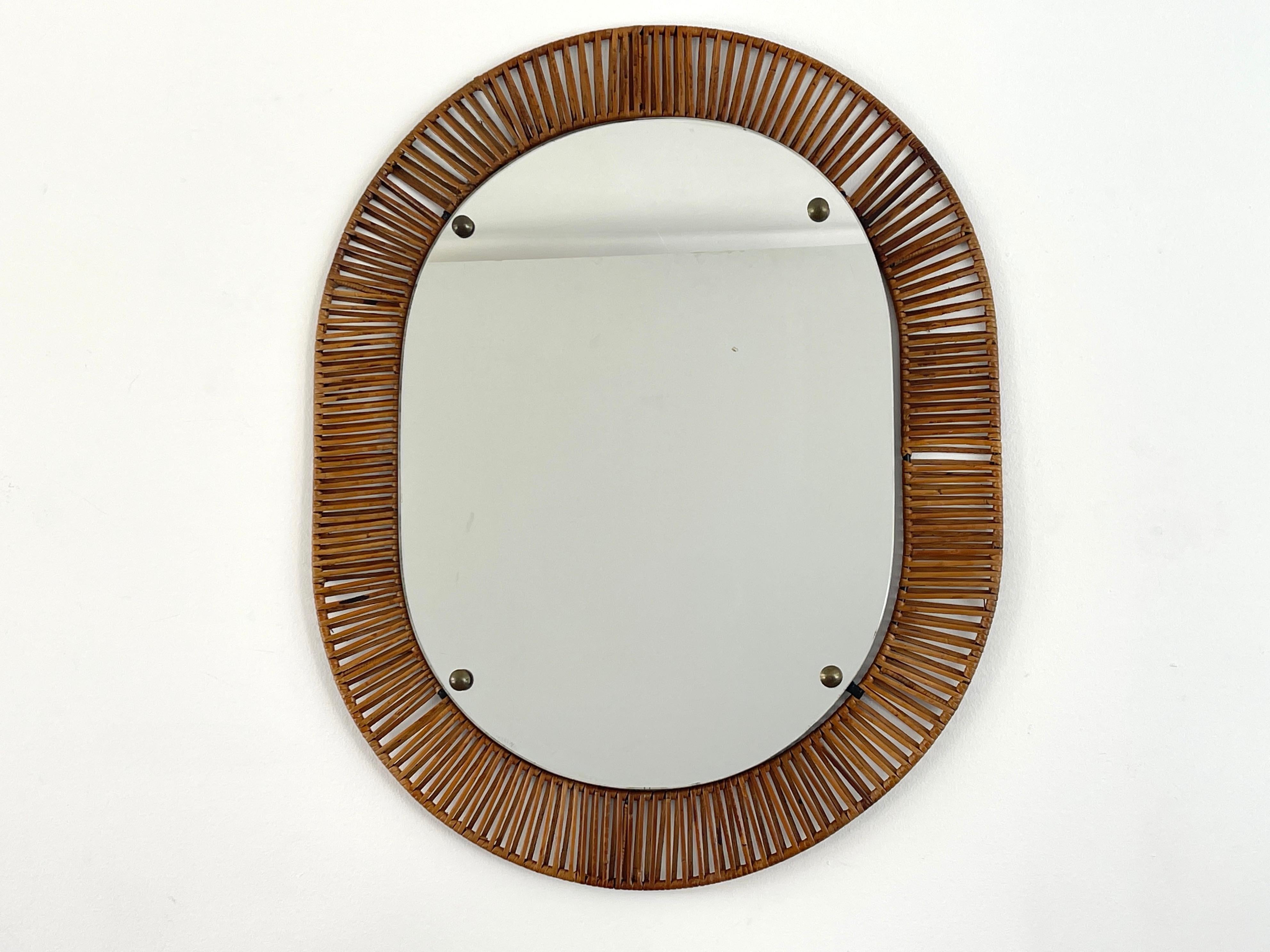 1950's Italian bamboo mirror in oval shape with brass accents.