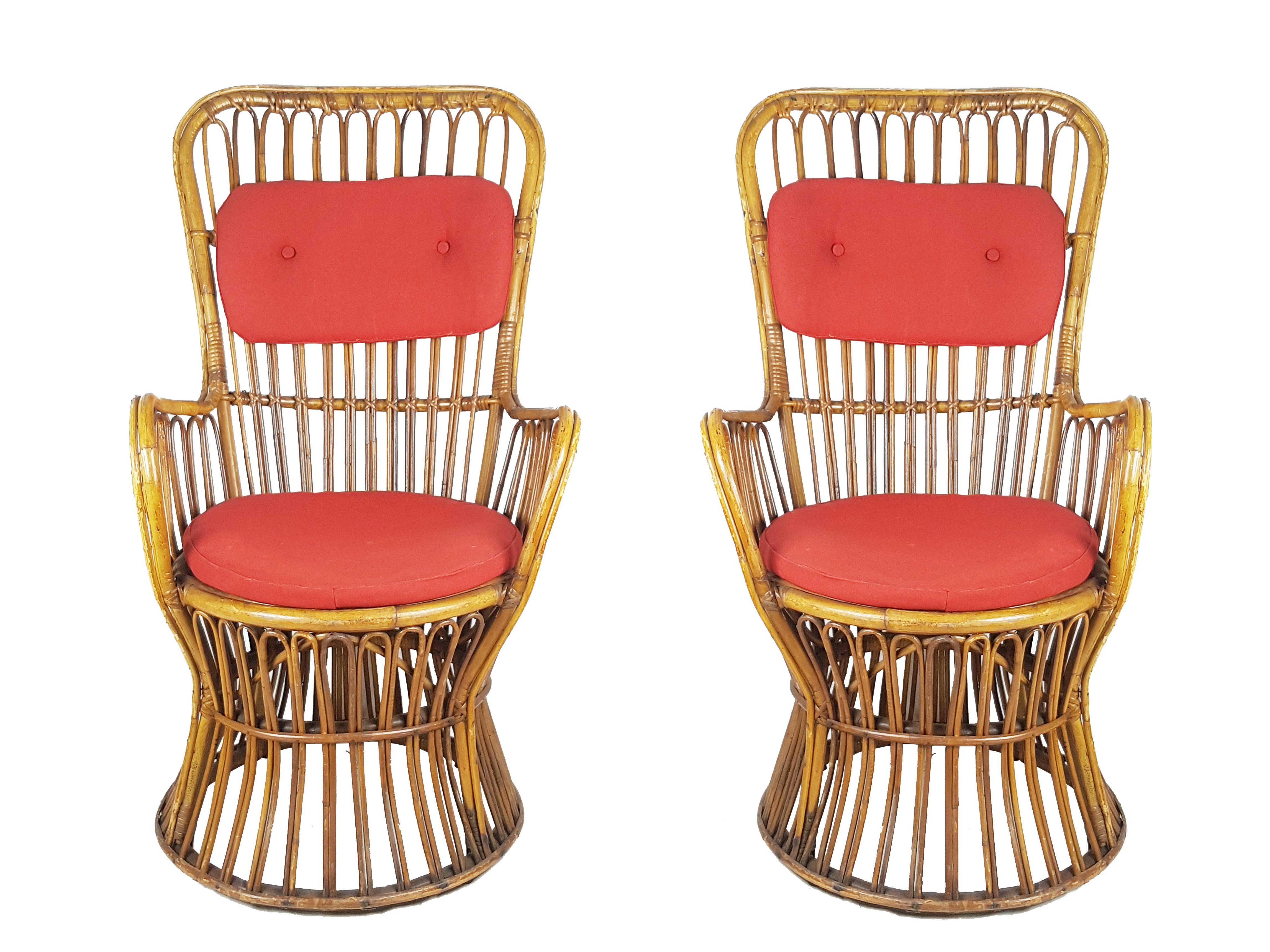 This beautiful pair of rattan and rush armchairs was produced in Italy in the late 1950s. Their high quality and fine design resemble similar examples of the contemporary Azucena production. The chairs feature their original red fabric pillows and