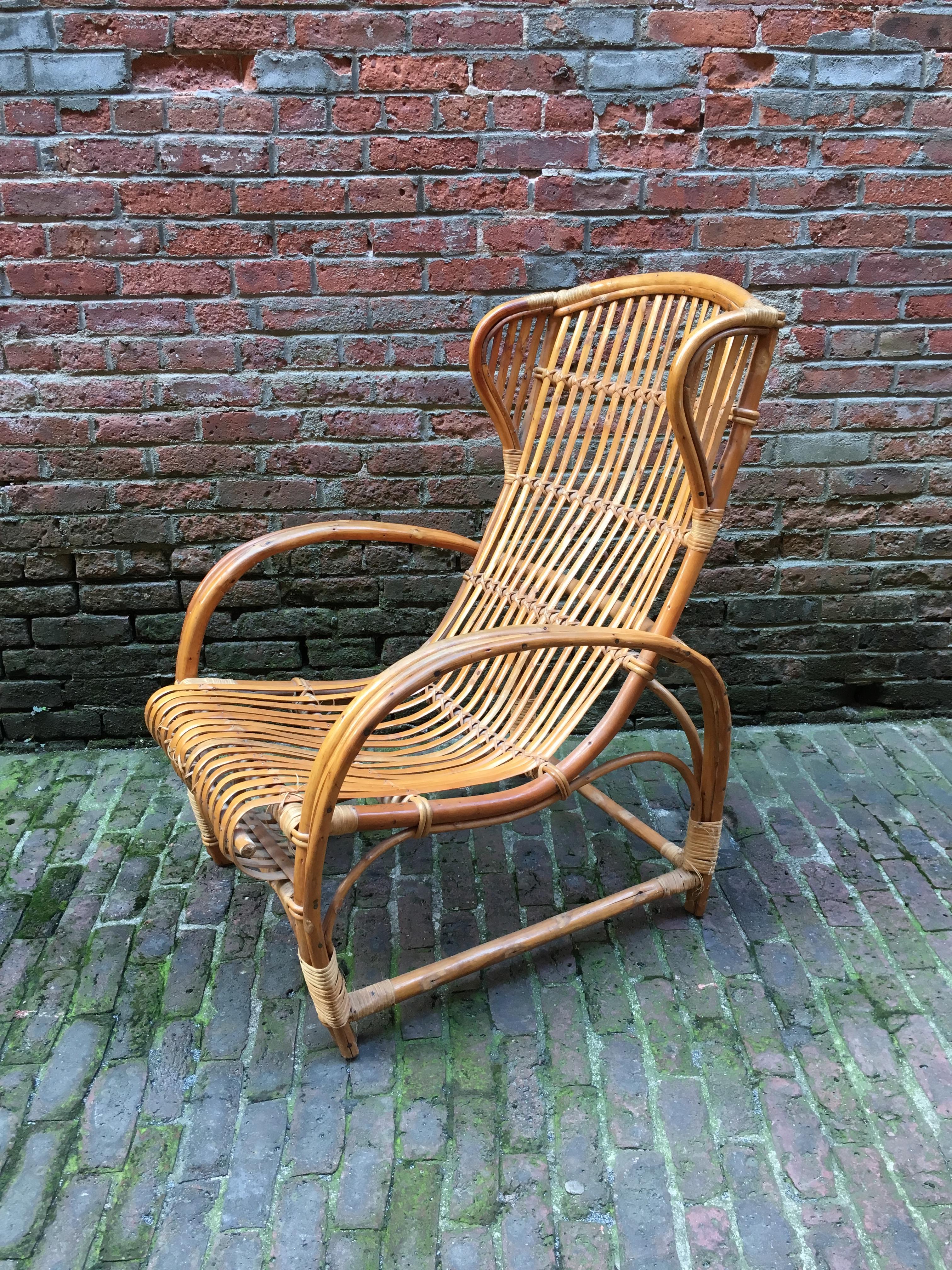 Quality rattan armchair in the manner of Gio Ponti, Tito Agnoli or Lio Carminati. Curved and contoured back for ultimate comfort, circa 1950-1960.