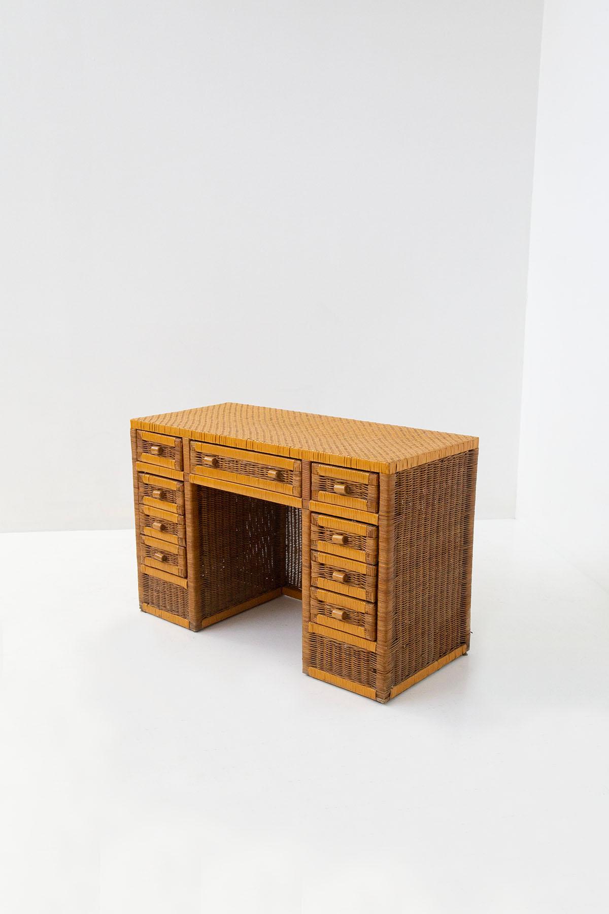 Eccentric Italian-made desk totally made of rattan from the 1970s. Made of tubular metal, cladding in exotic wood and woven Indian cane. The desk features nine total drawers, four of which are in the right section , four in the left section is a the
