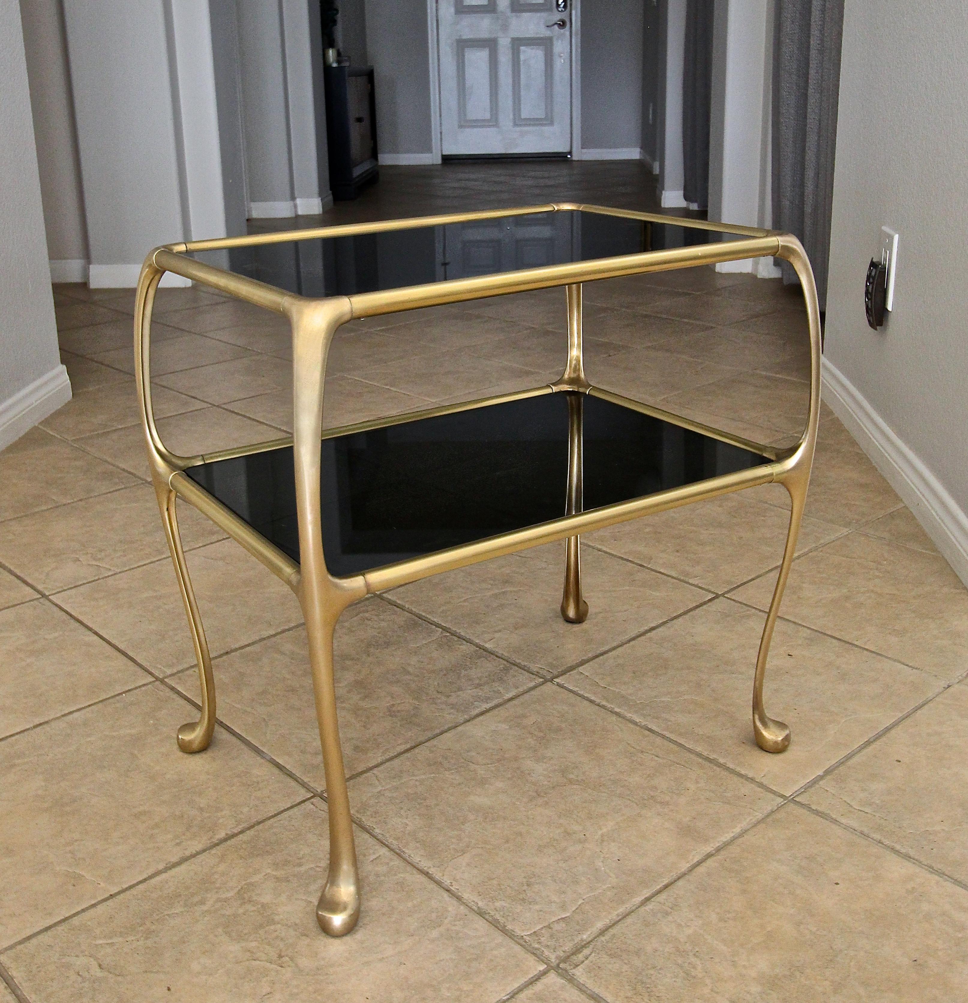 Italian brass 2-tier rectangular side or occasional end table, with newer dark tinted glass insert tops. Unique design with bowed cabriole style legs. Solid heavy brass construction.