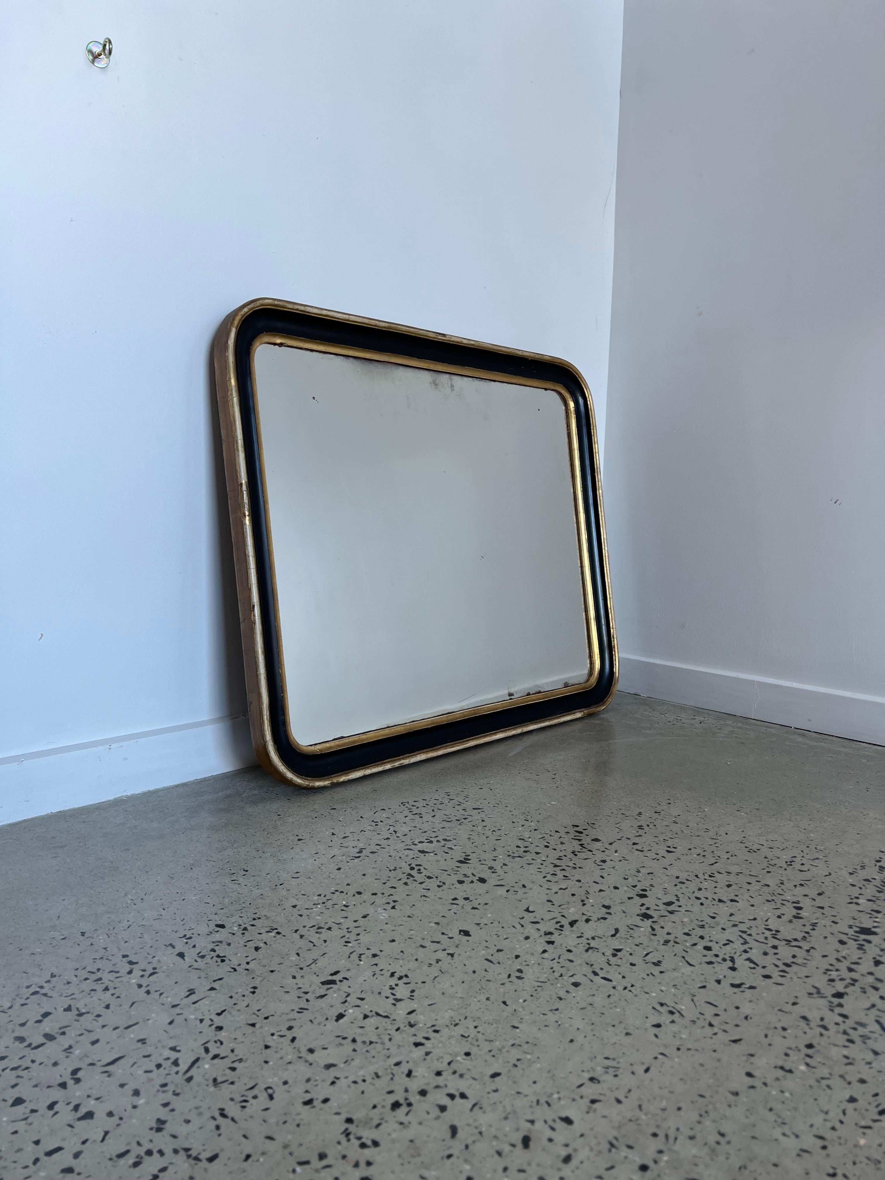 Miroir italien des années 1940 en bois doré à la feuille.
Magnifique miroir rectangulaire, le cadre est peint en noir et la technique de la feuille d'or le long des bords.
 