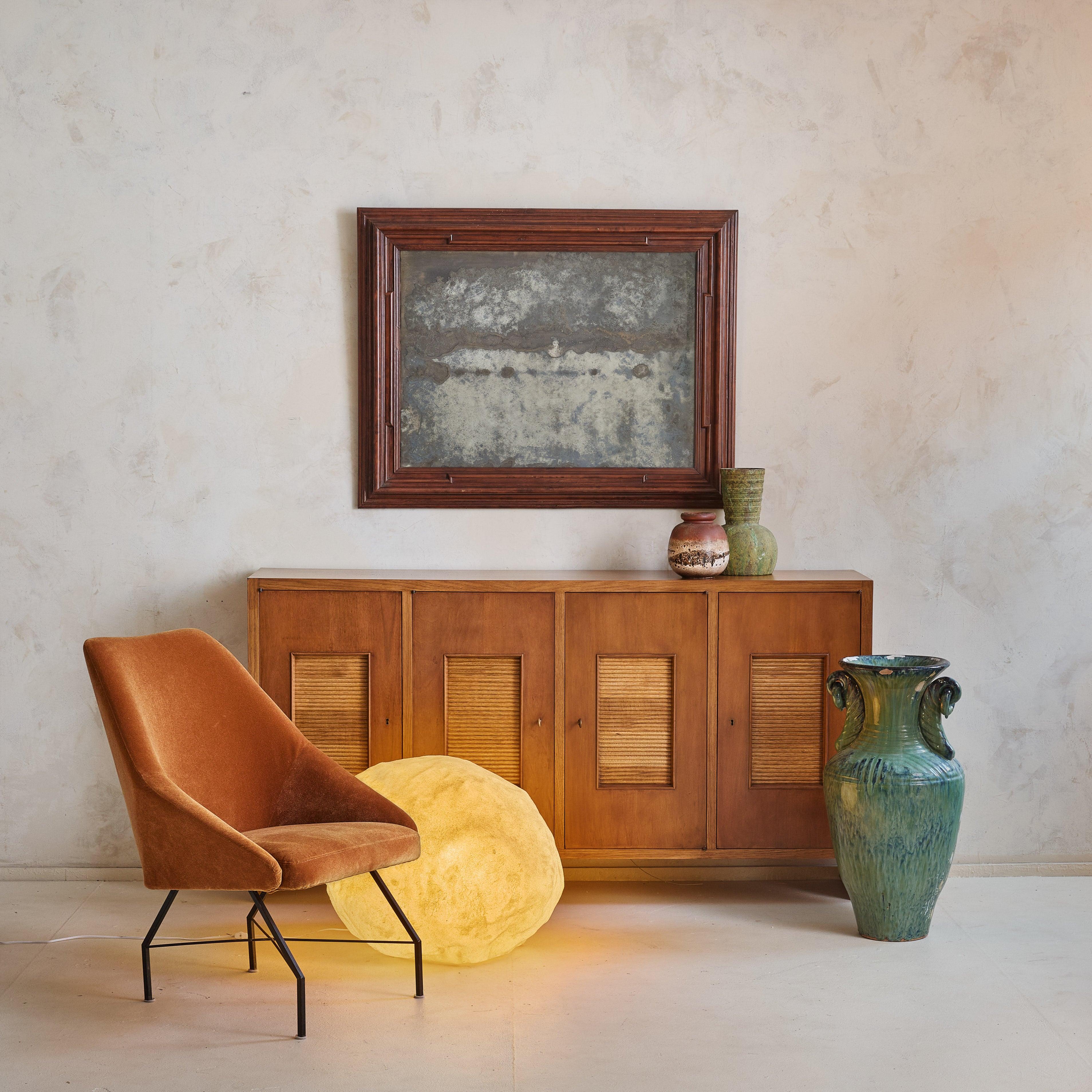 Crafted in the Piedmont region of Italy, this rectangular solid wood wall mirror dates back to the early 19th century. Its detailed frame is defined by intricate carvings and textured accents, emphasizing the rich tone and natural grain of the wood.