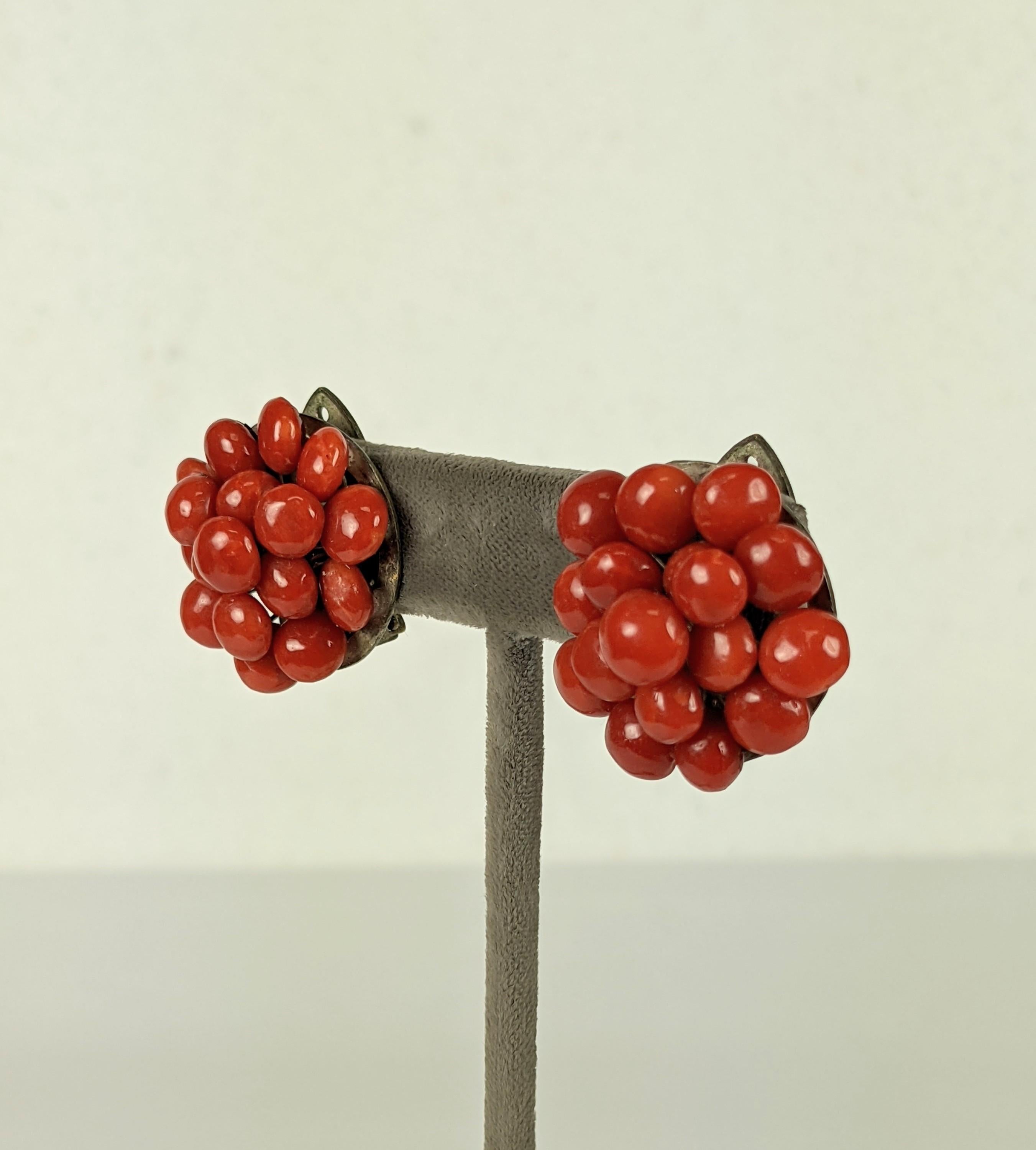 Italian red coral clips composed of button like tablets.  Fashioned of two concentric layers of the coral tablets with a larger coral button in the center. Set on gilt metal wire frame. Can be worn as ear clips or dress clips.
1930'S Italy.