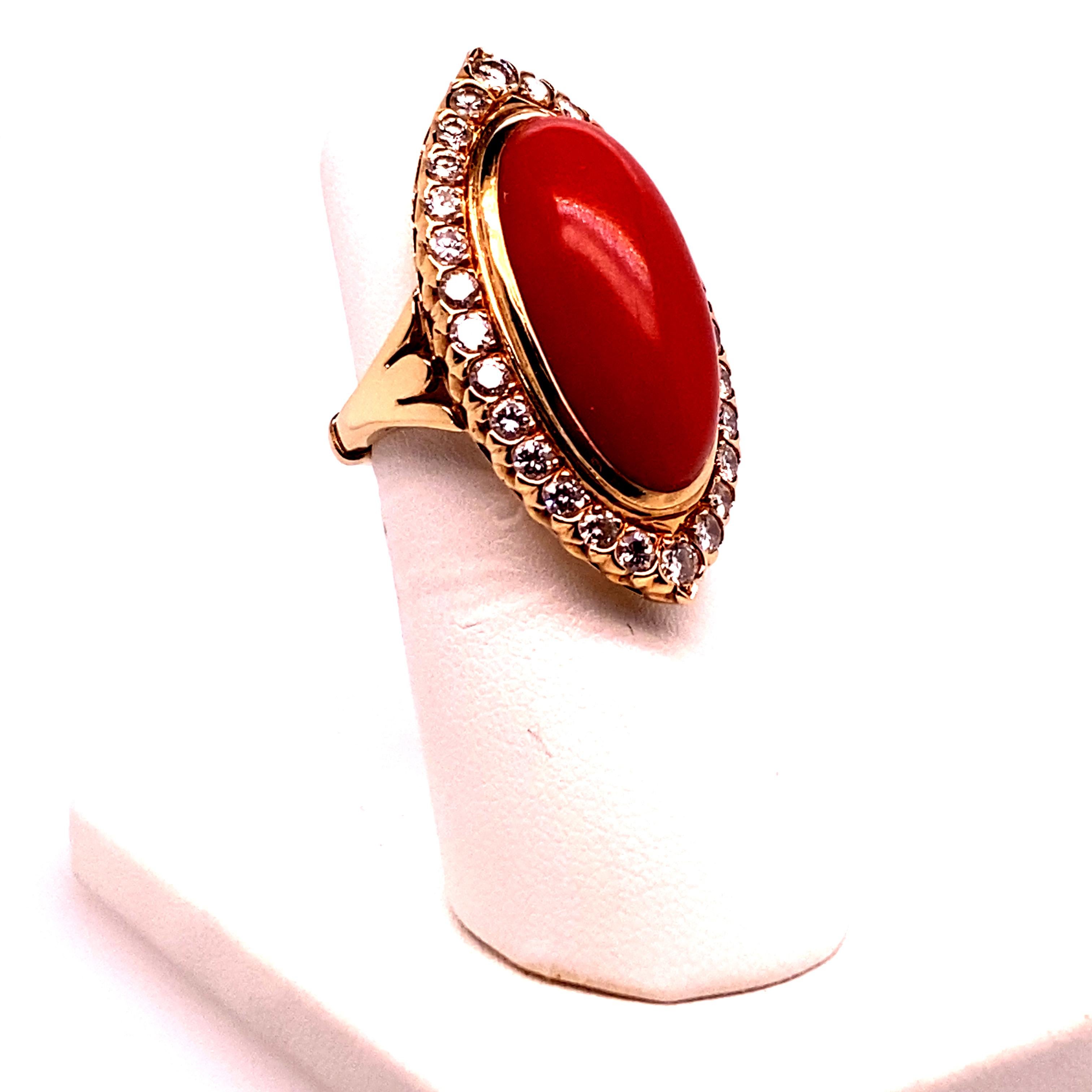 14kt Yellow gold vintage ring from Italy.  Featuring one oval cut red coral cabachon measuring aproxiamtely 22x12mm and twenty eight round, full cut diamonds weighing aproximate;y 1,50 cts total.  Color grade G-H, clarity grade SI1-2.  The ring