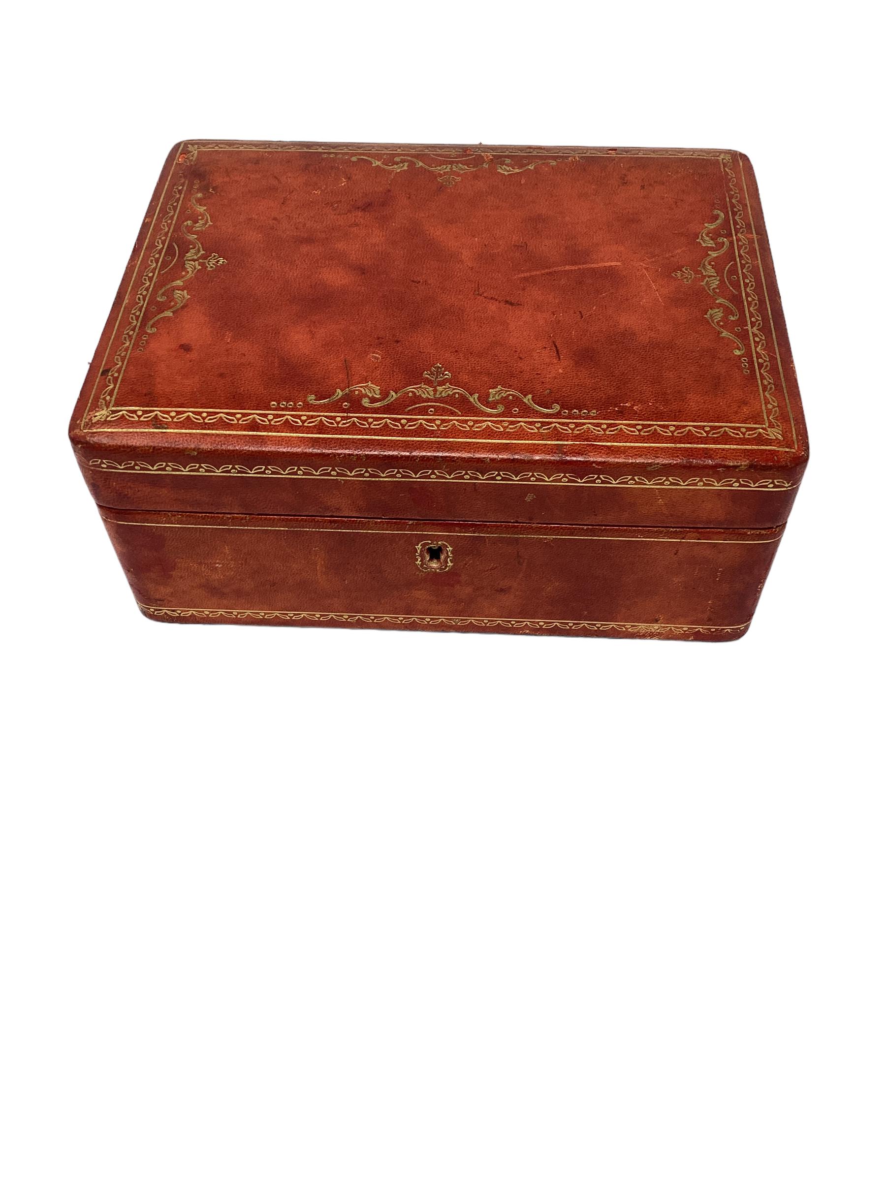 Italian Red Leather Jewelry Box with Gold Tooling. The top opens to reveal a red velvet lined interior. There is a tray that lifts out to reveal more storage and space to store rings. Leather shows wear as well as scuffs and markings.