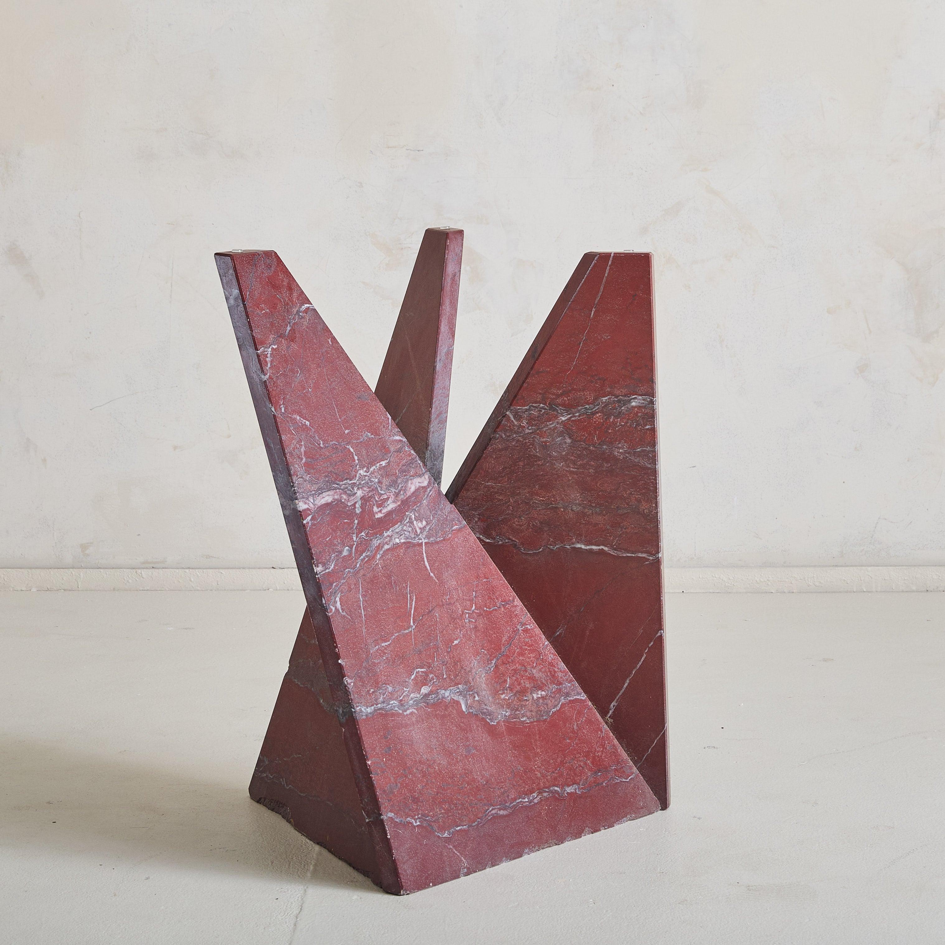 A 1970s Italian Modernist design with proportions that allow versatility as either a side or center table. The base, constructed from deep red marble, captivates with its angular forms, creating a sculptural presence that is both dynamic and