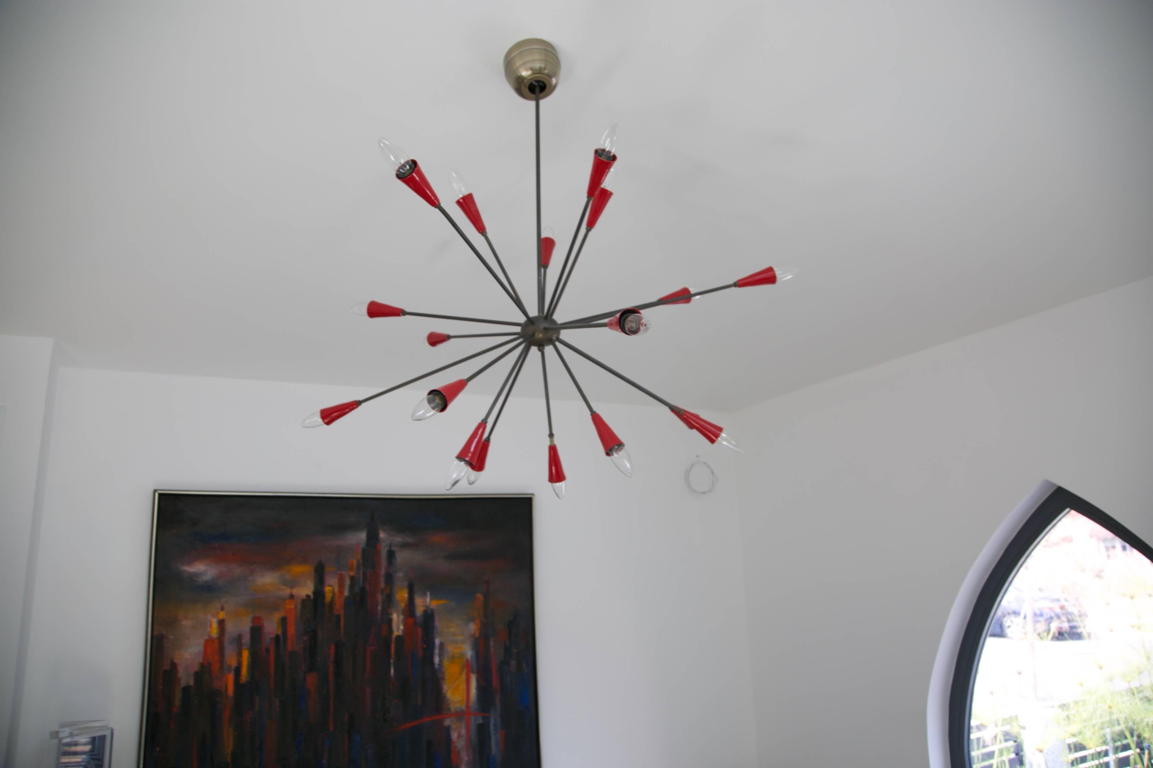 Eye-catching Italian chandelier circa 1950 attributed to Stilnovo. This classic light fixture is comprised of seventeen black arms projecting from a spherical center with contrast red cone sockets at the ends. An amazing way to add some pop color to