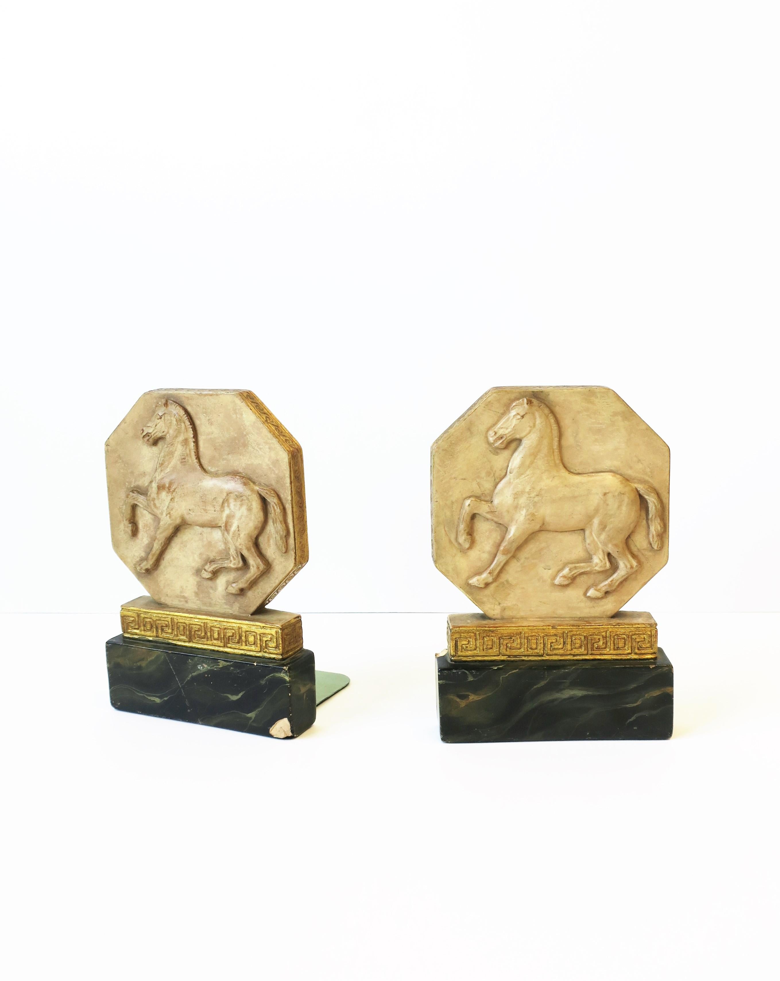 A pair of vintage Italian Regency style chalkware bookends with horse and gold gilt Greek-Key Design, circa early-20th century timeframe, Italy. Dimensions: 4.38