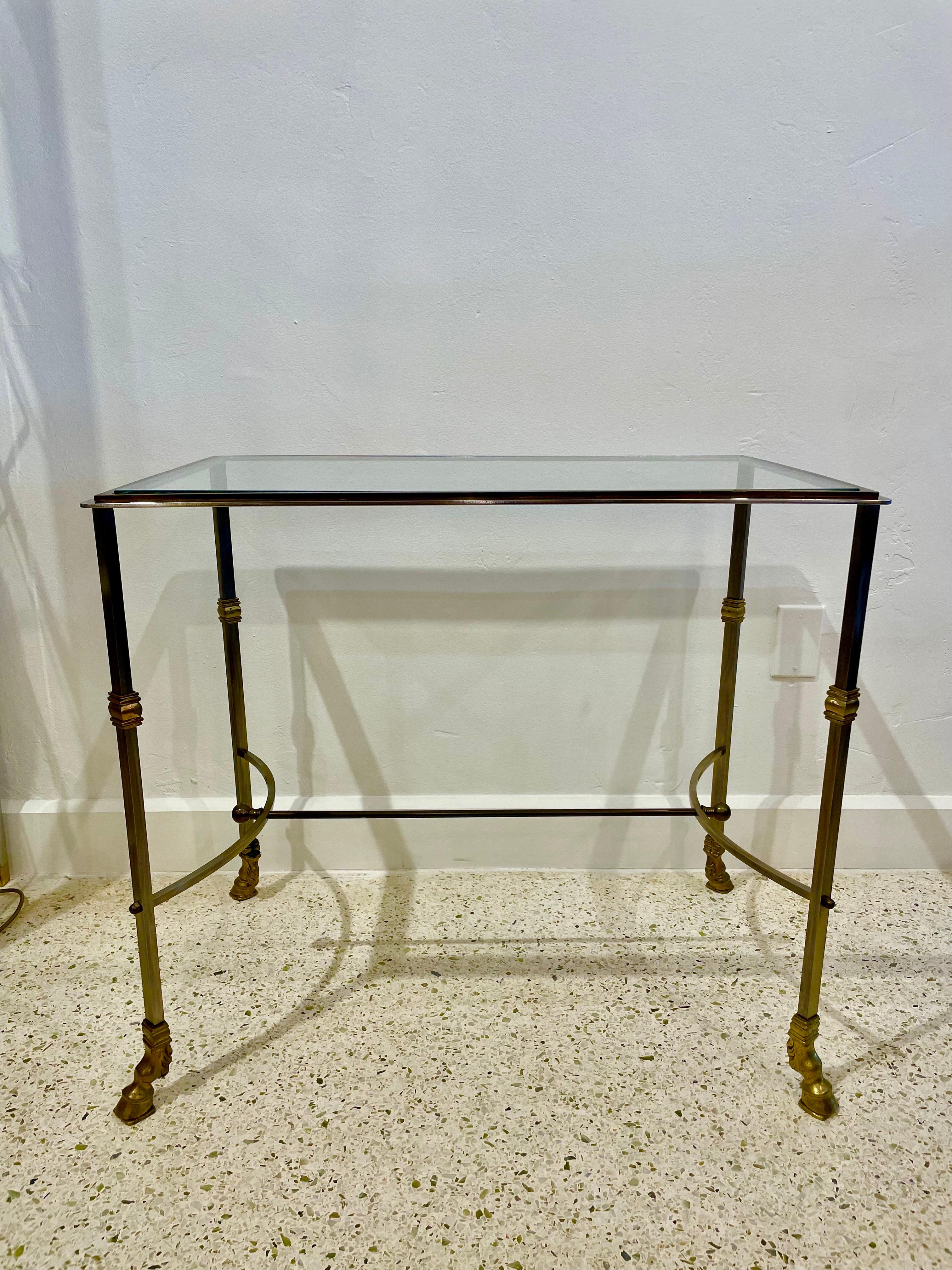 This two-toned console (brass and brushed steel) has a glass plateau and brass stretcher.  ALL original and in wonderful condition with age and patina to brass and steel.  
