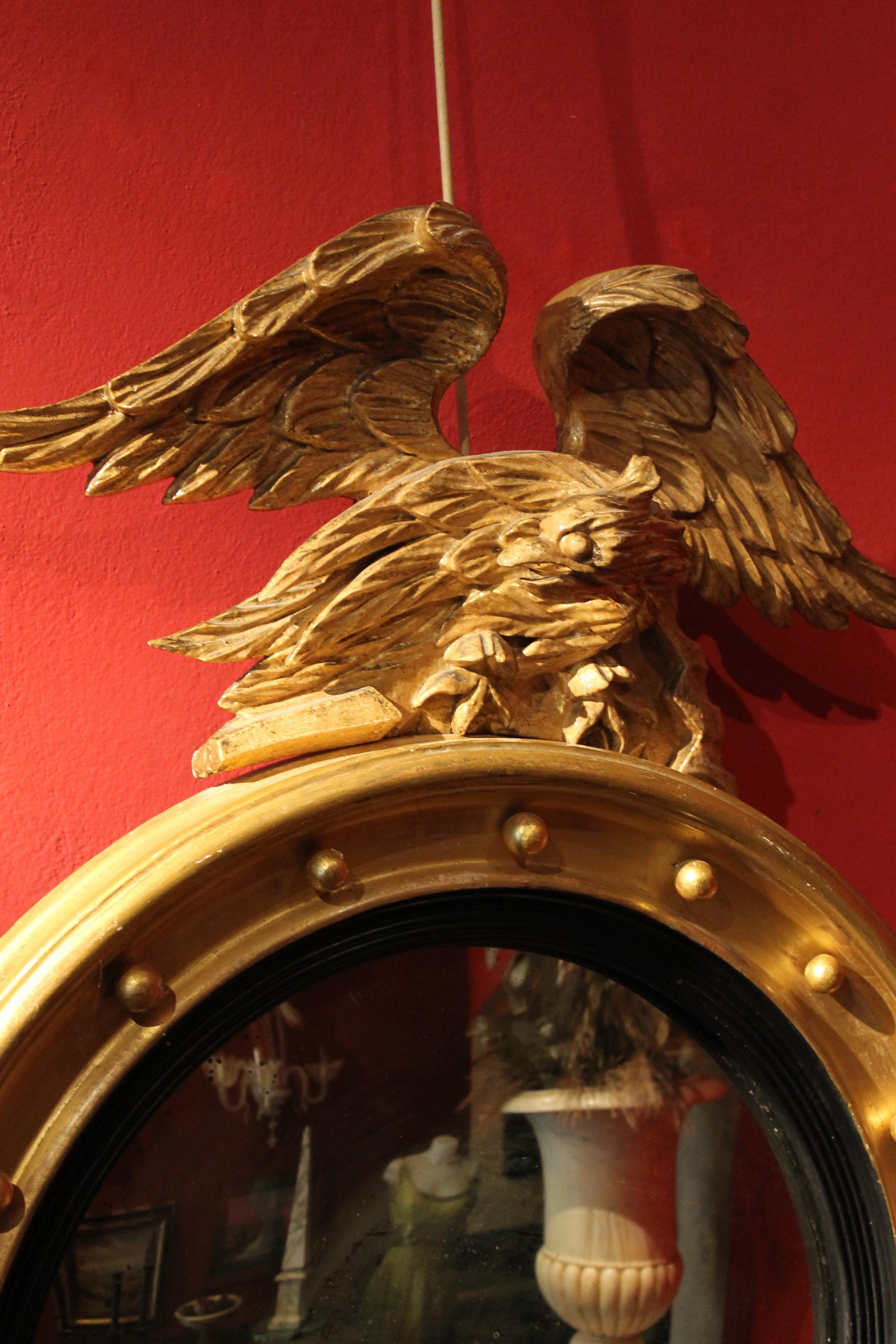 Bois Miroir rond de style Régence italienne en bois doré et ébène avec aigle sculpté en vente