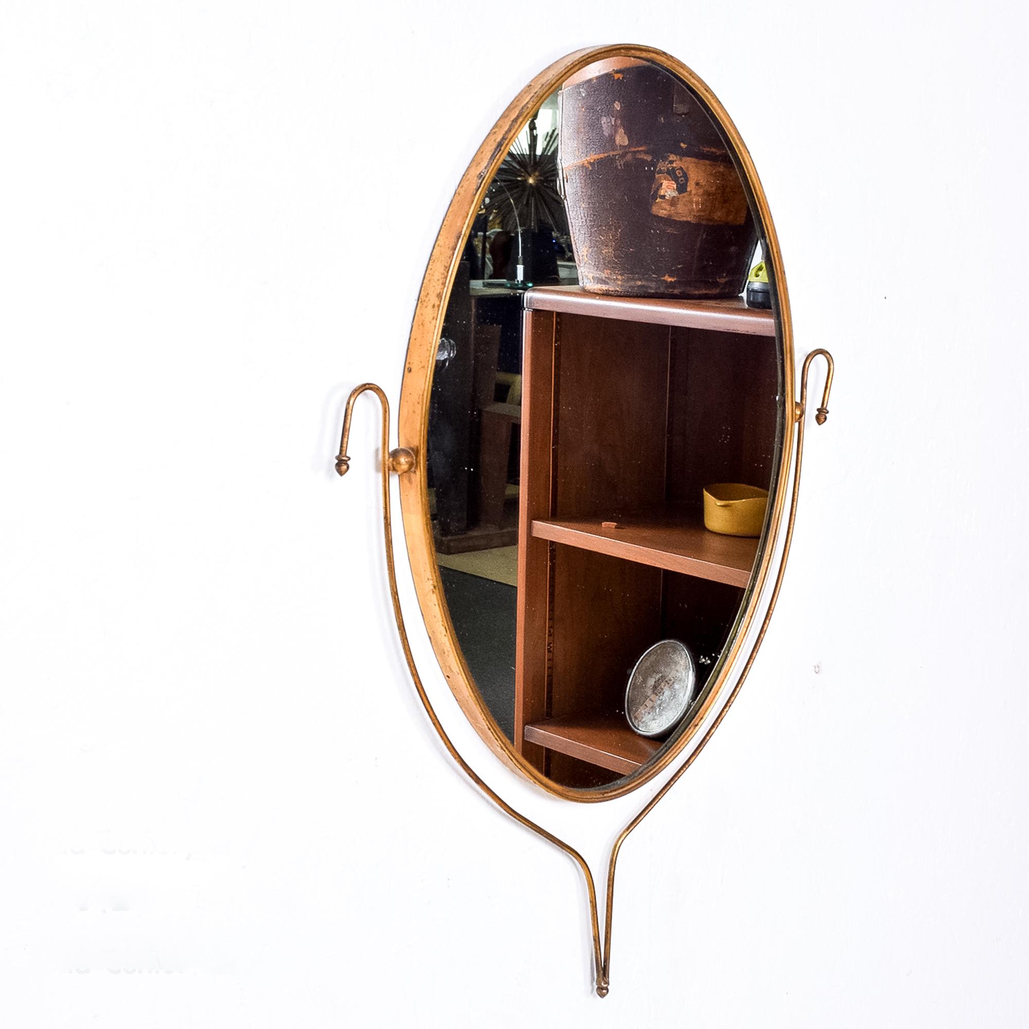 Italian Regency vintage sculptural wall mirror in an oval shape elegant simple style of Gio Ponti (Designer) and Fontana Arte (Manufacturer) piece is Unmarked. Italy, circa 1950s.
It includes a new glass mirror. Brass frame retains original vintage