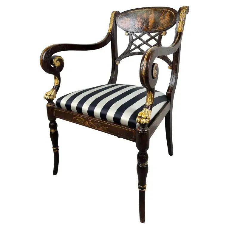  An elegant Italian regency style ebonized armchair or side chair. The chair is ebonized and embellished with gold accents, especially on the armrests and legs, adding to the luxurious feel, which is typical of Regency furniture.
The regency style