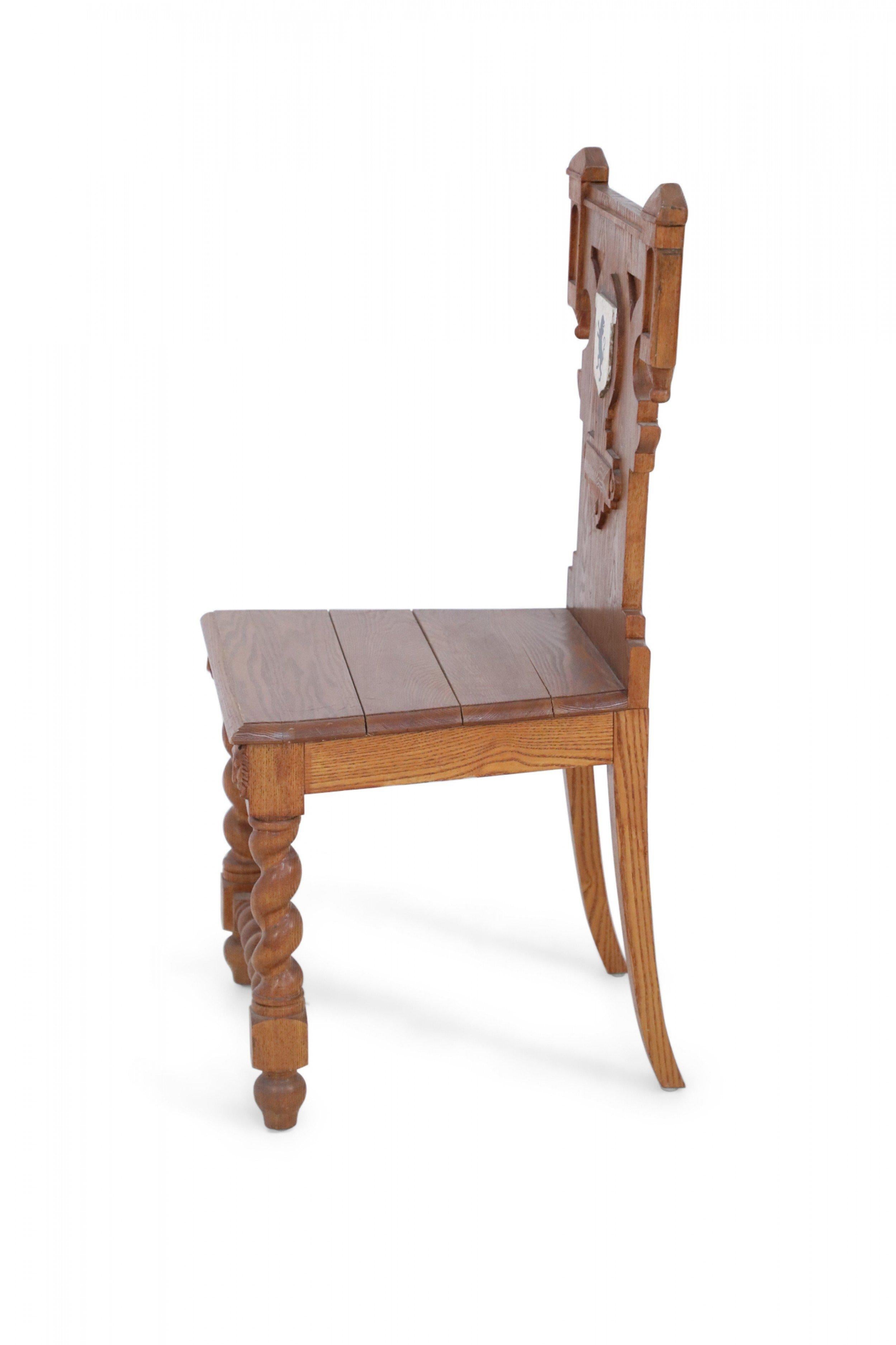 Italian Renaissance-style carved wooden chair with spiral turned front legs and stretcher, rear saber legs, and a back featuring a painted white crest with a central black lion.
 