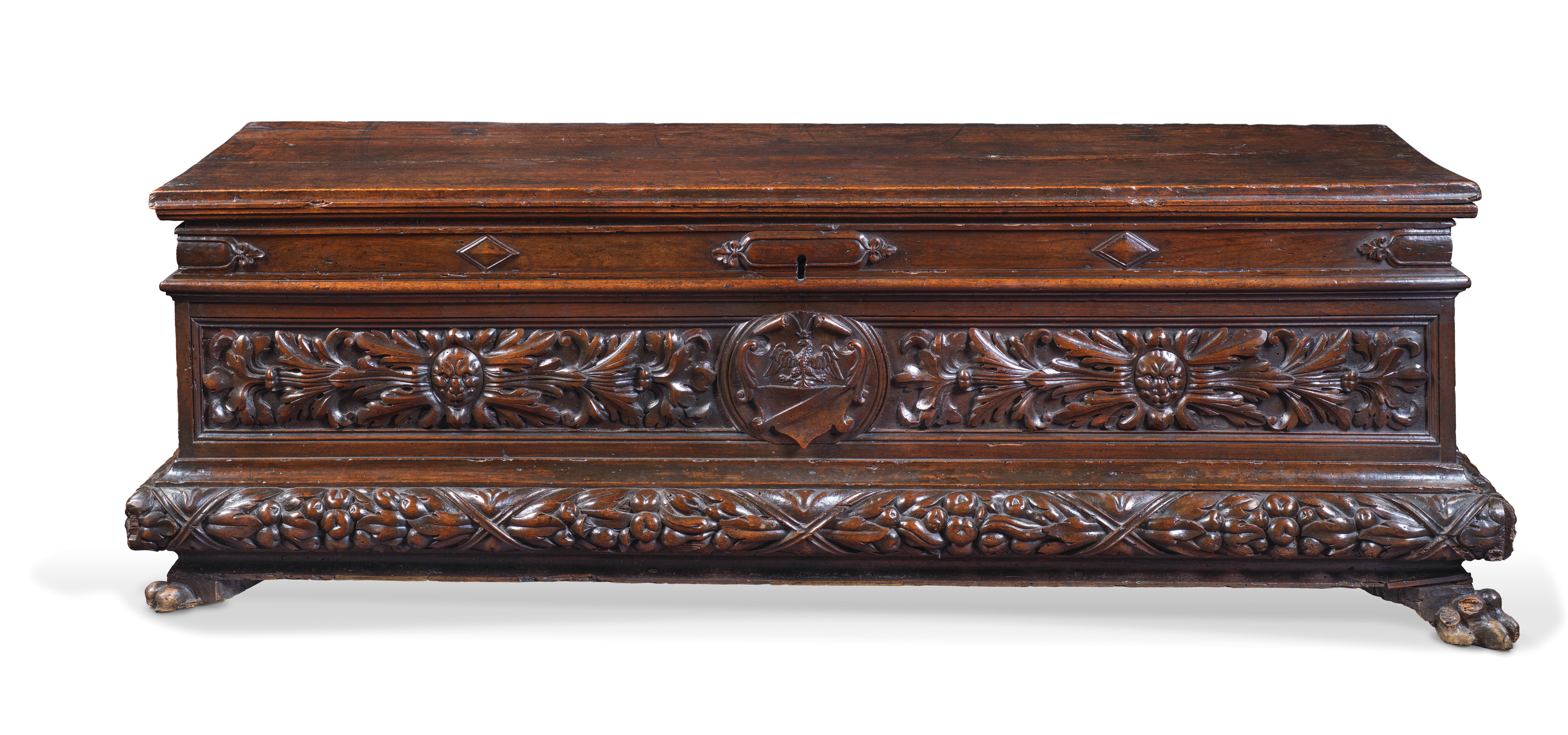 This Italian walnut chest called « cassone » is shaped as an antic sarcophagus. The beautiful patina and the plain lid bring to the fore the facade richly ornated with vegetal motifs and masks. The lateral sides are more soberly executed while the
