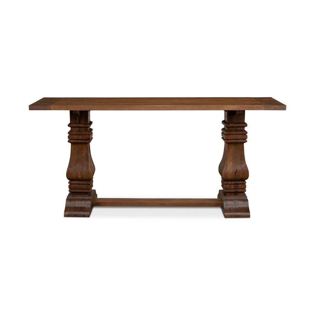 
A paragon of classic design that brings together form and function to stand as a masterpiece in your home. With its dual pedestal base featuring bold square baluster carved legs, this console table is a testament to traditional woodworking