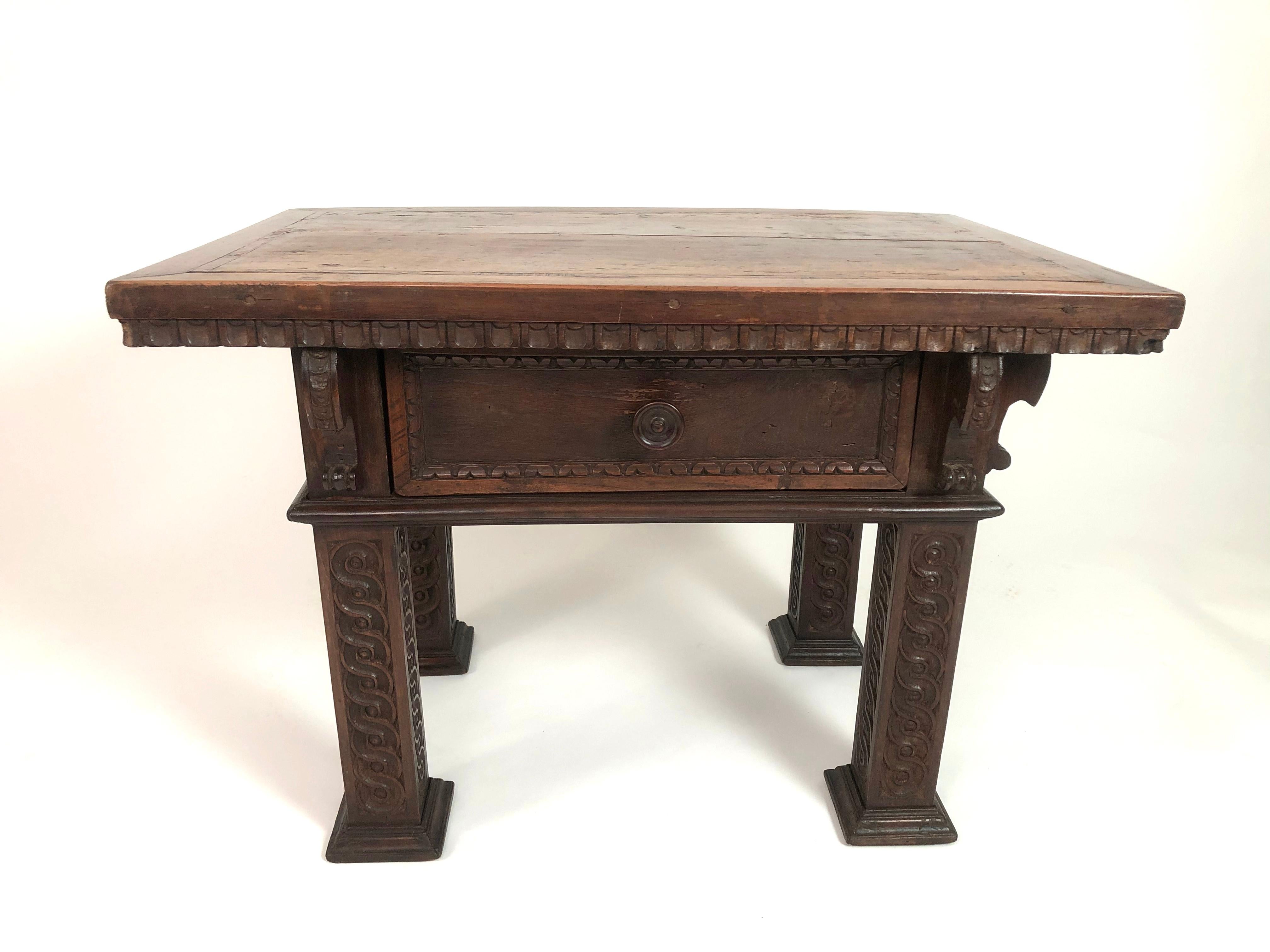 A well made and beautifully designed Italian Renaissance Revival carved oak and walnut side or coffee table, of rectangular form, the inlaid top over a single deep drawer, supported by four square section legs carved with graphic guilloche pattern.