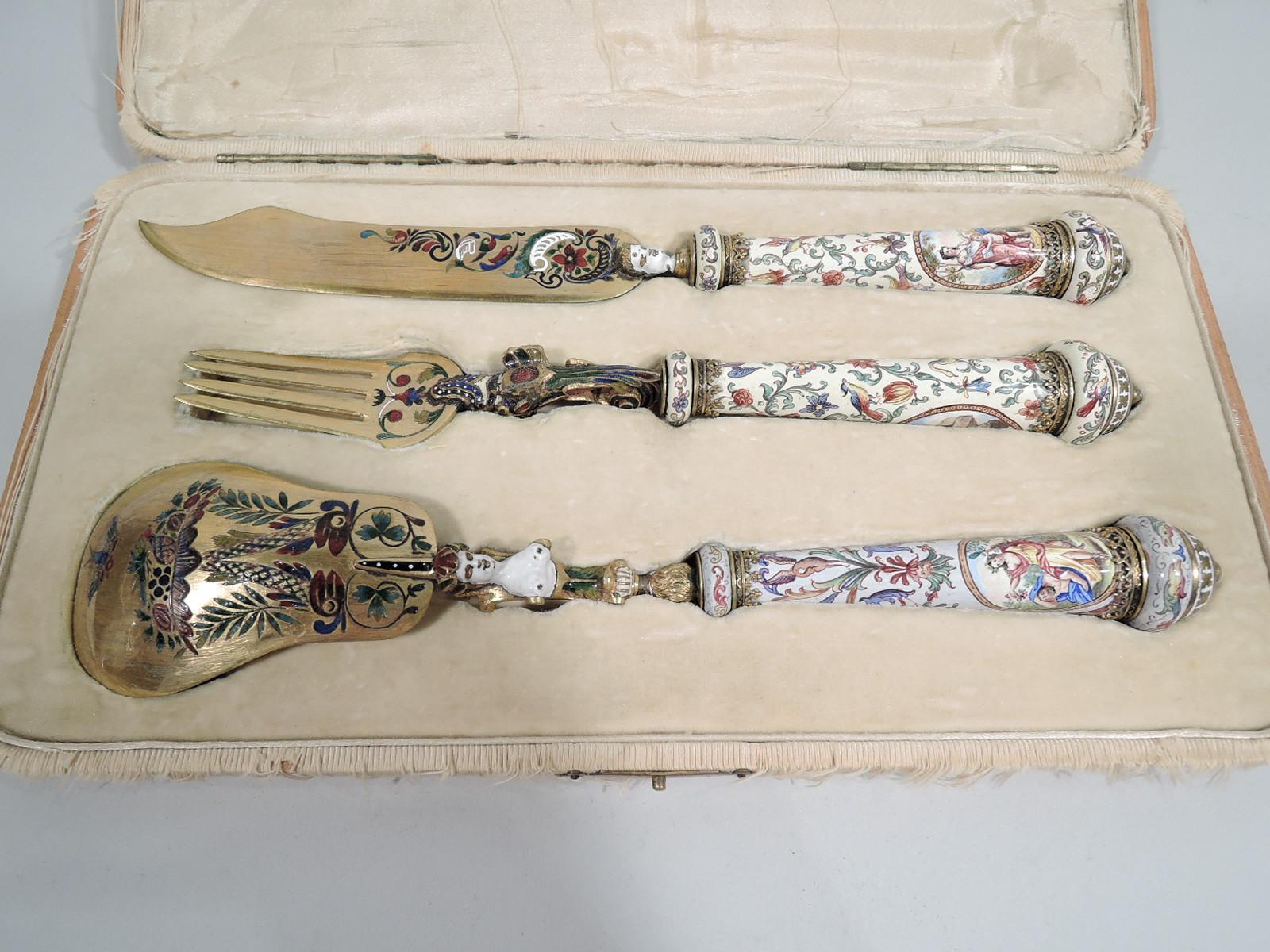 Italian Renaissance-Revival 3-piece gilt brass and enamel serving set, ca. 1860. This set comprises spoon, fork, and knife.

The handles are straight and tapering with knops and enameled grotesque ornament on white ground. The spoon has shaped