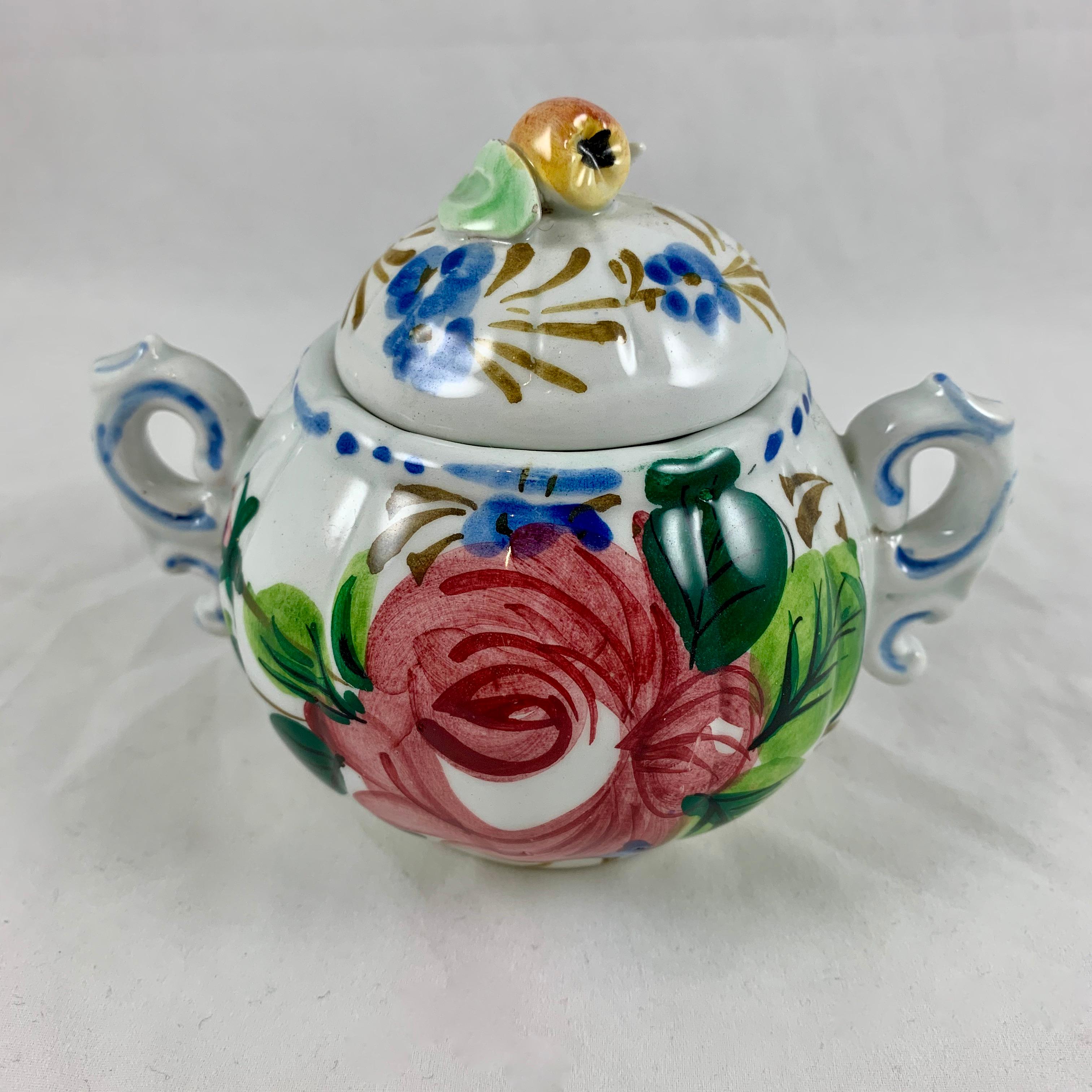 In the Renaissance Revival Rose pattern from the Barrettoni già Antonibon pottery in Nove, Italy, a covered and handled sugar bowl, circa 1930s.

A scarce hand painted piece in an overall floral decoration with a bright blue dash and dot border.