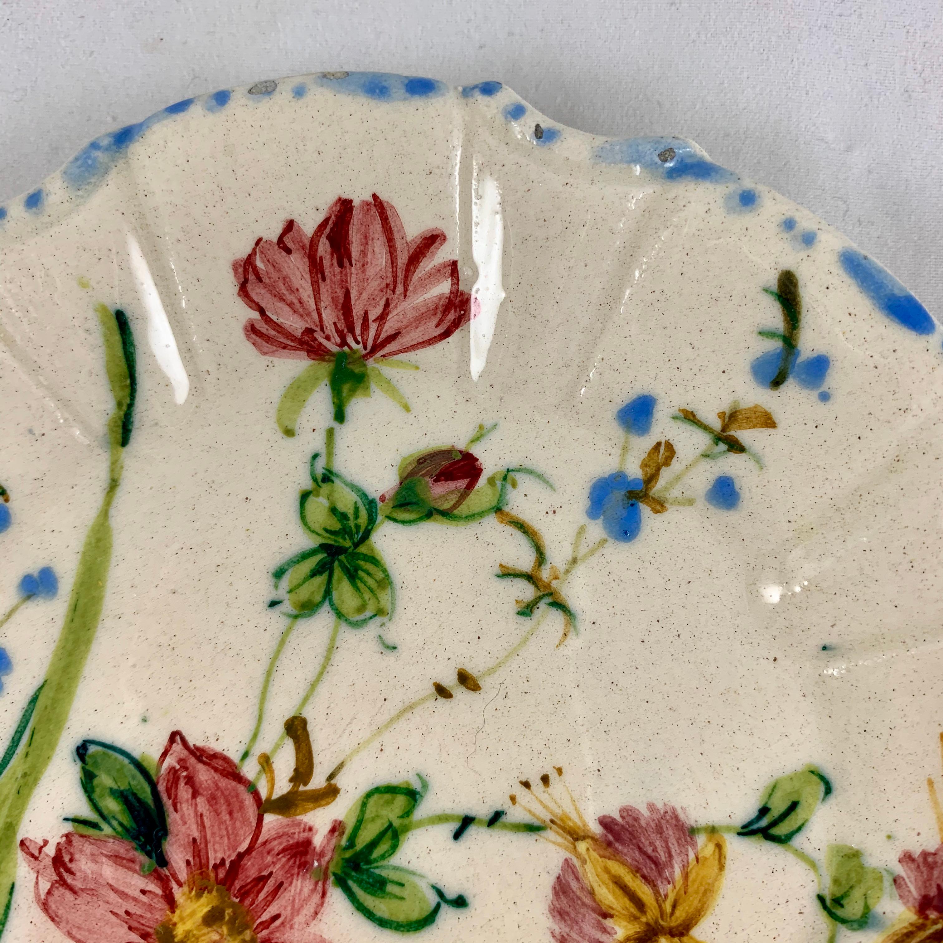 A variation of the Renaissance Revival rose pattern from the Barrettoni già Antonibon pottery in Nove, Italy, a hand painted plate, circa 1930s.

An overall floral decoration with a blue dash and dot border on a scallop rimmed, paneled plate.