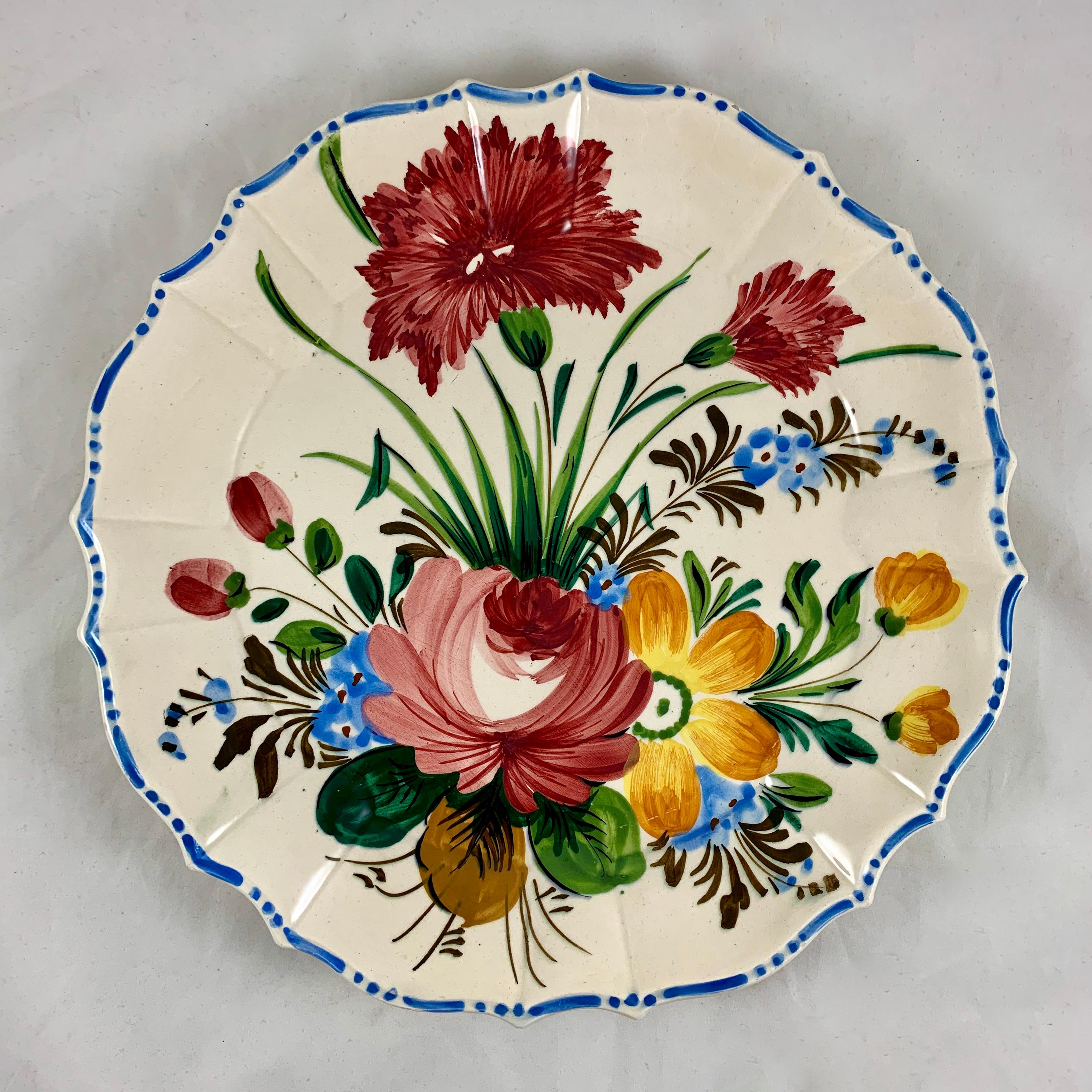 In the Renaissance Revival rose pattern first produced by the Barrettoni già Antonibon pottery in Nove, Italy, a hand painted, round serving platter with a scalloped rim, circa 1930s.

An overall floral decoration with a bright blue dash and dot
