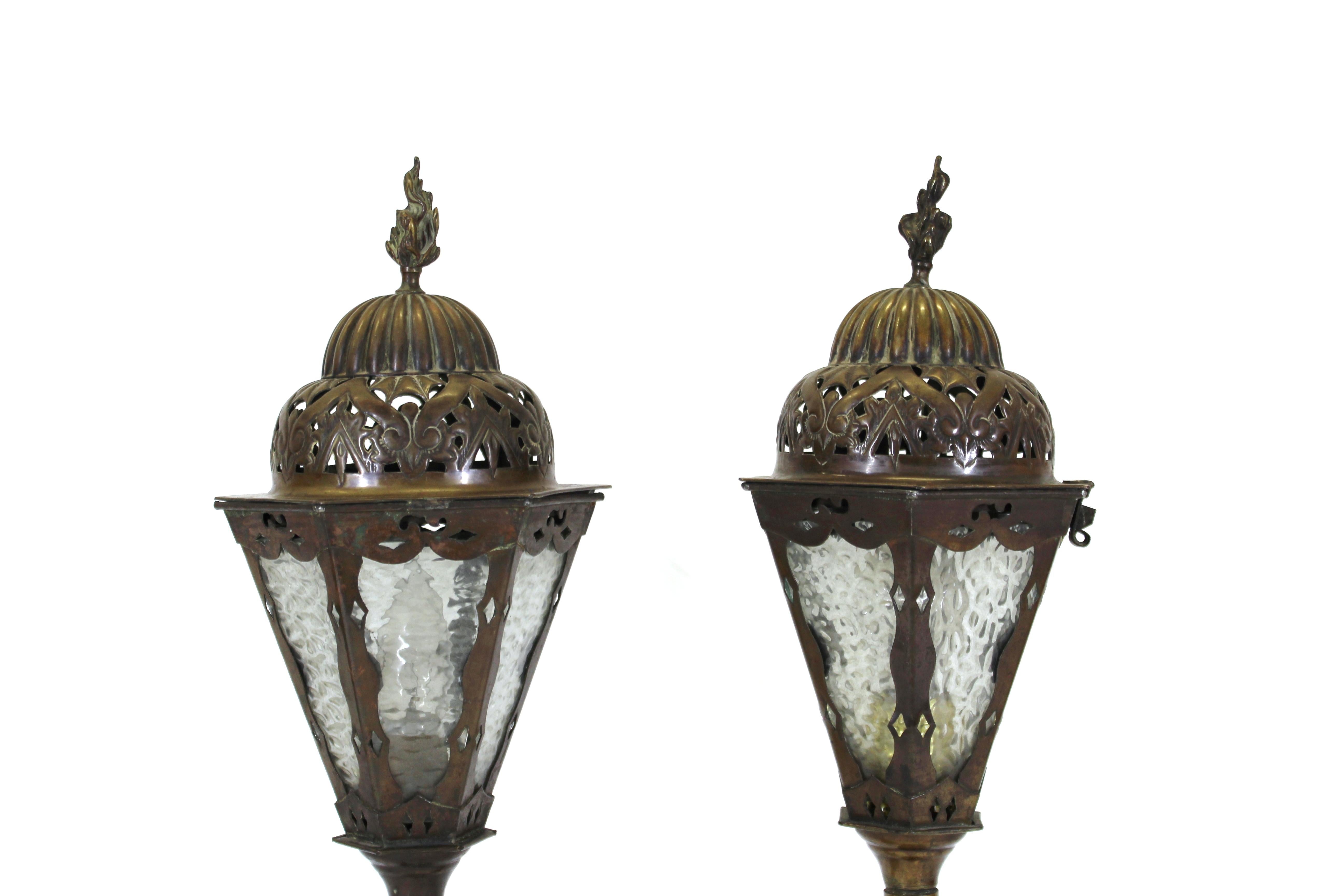 Italian Renaissance Revival pair of lantern table lamps in cast bronze, with brass repousse detailing and glass inserts. Handmade in Italy during the 1900s, the pair is in remarkable antique condition with age-appropriate wear and use.