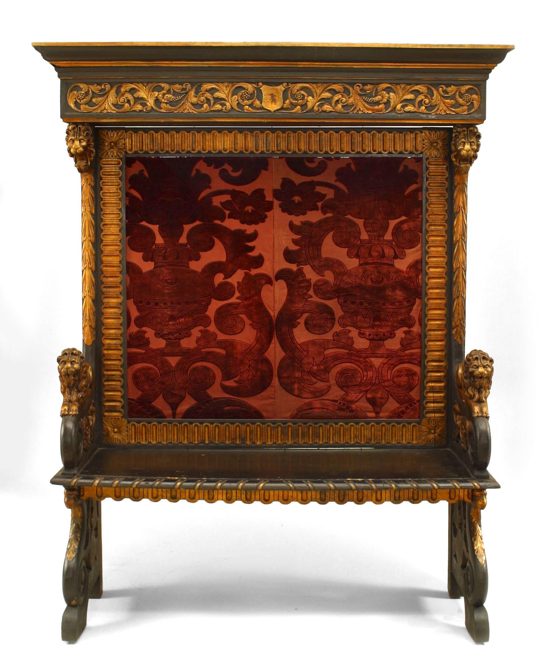 Italian Renaissance style (19th Century) ebonized and gilt trimmed hall bench with lion carved arms and cut red velvet back panel.
