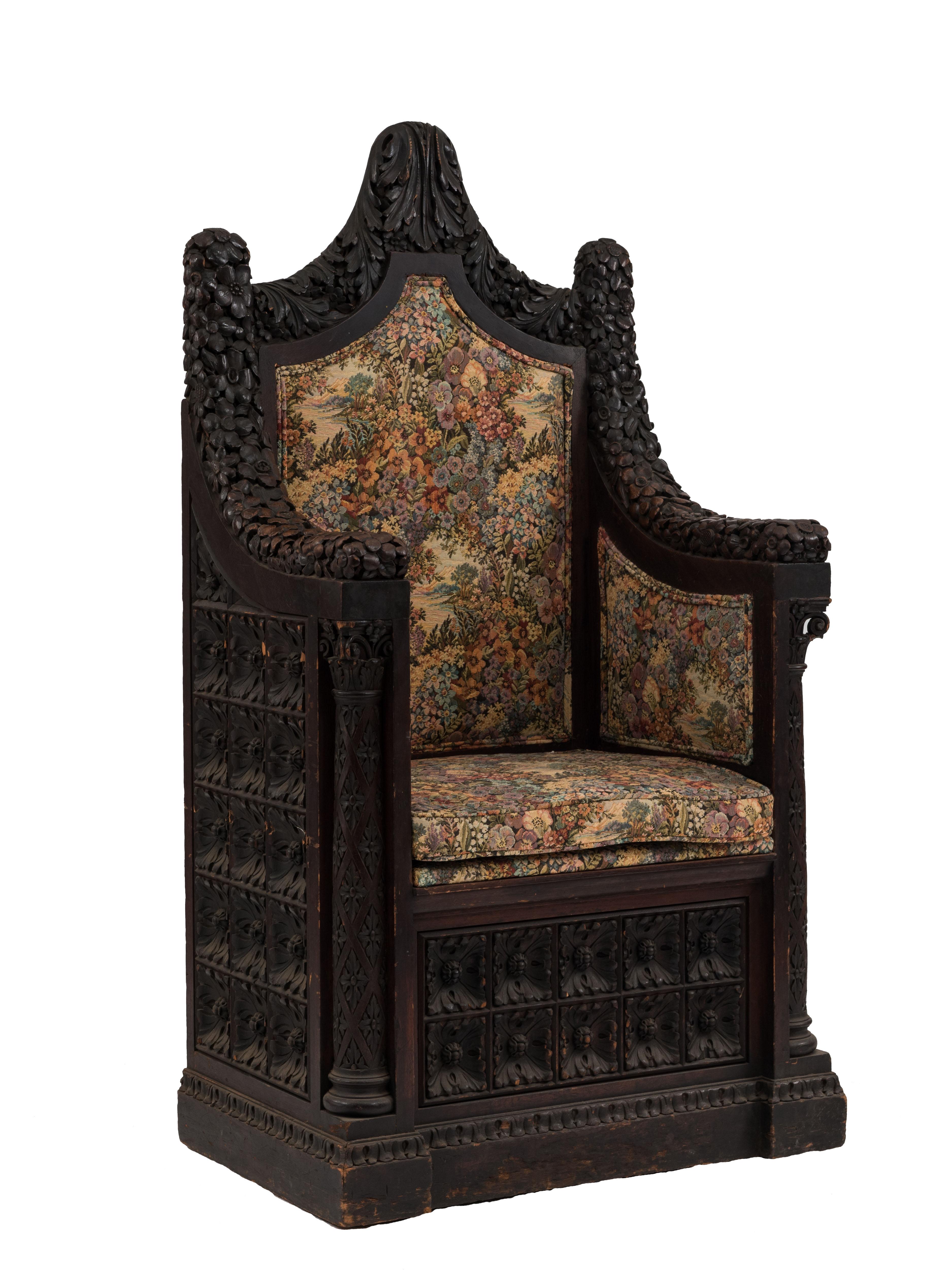 Sillón trono de nogal de estilo renacentista italiano (s. XIX) con respaldo alto y columna, diseño floral tallado y tapicería de tapiz.
 