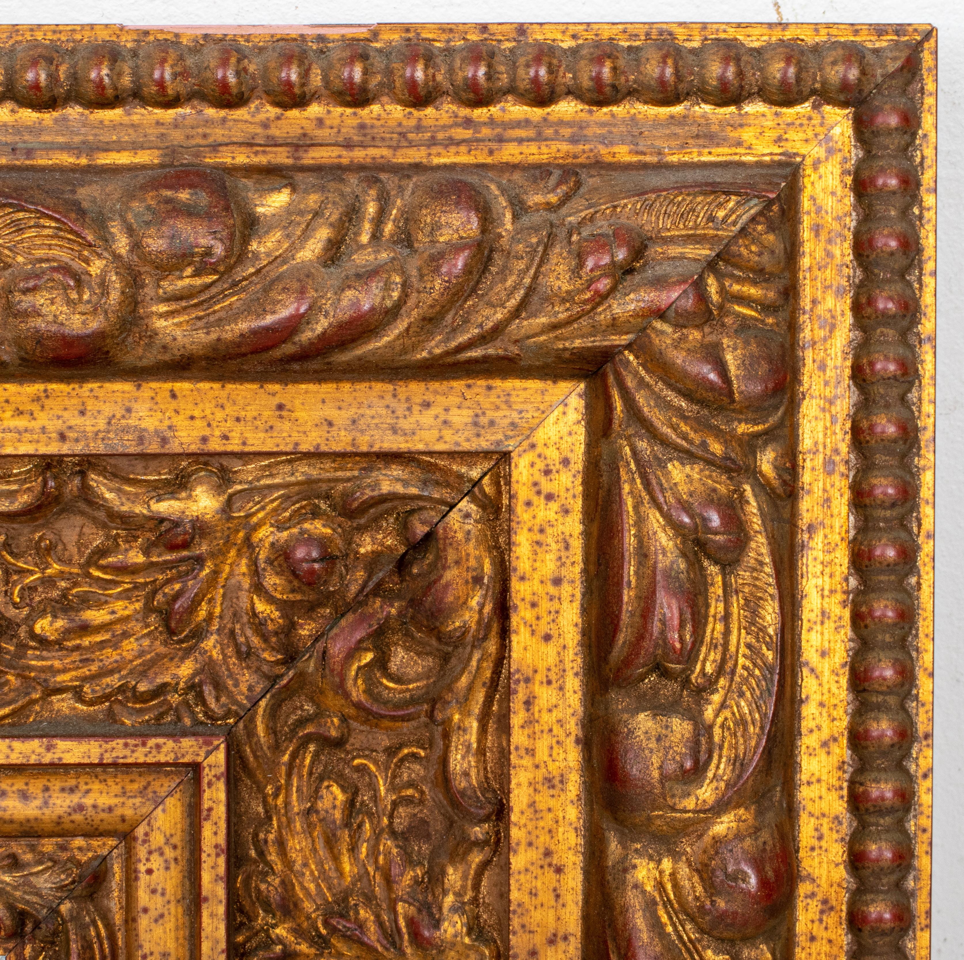 Italian Renaissance style gold-decorated frame, in the 16th century taste centering a beveled mirror surrounded by carved scrolling foliate and harvest motifs within a beaded border. 

Measures: 22